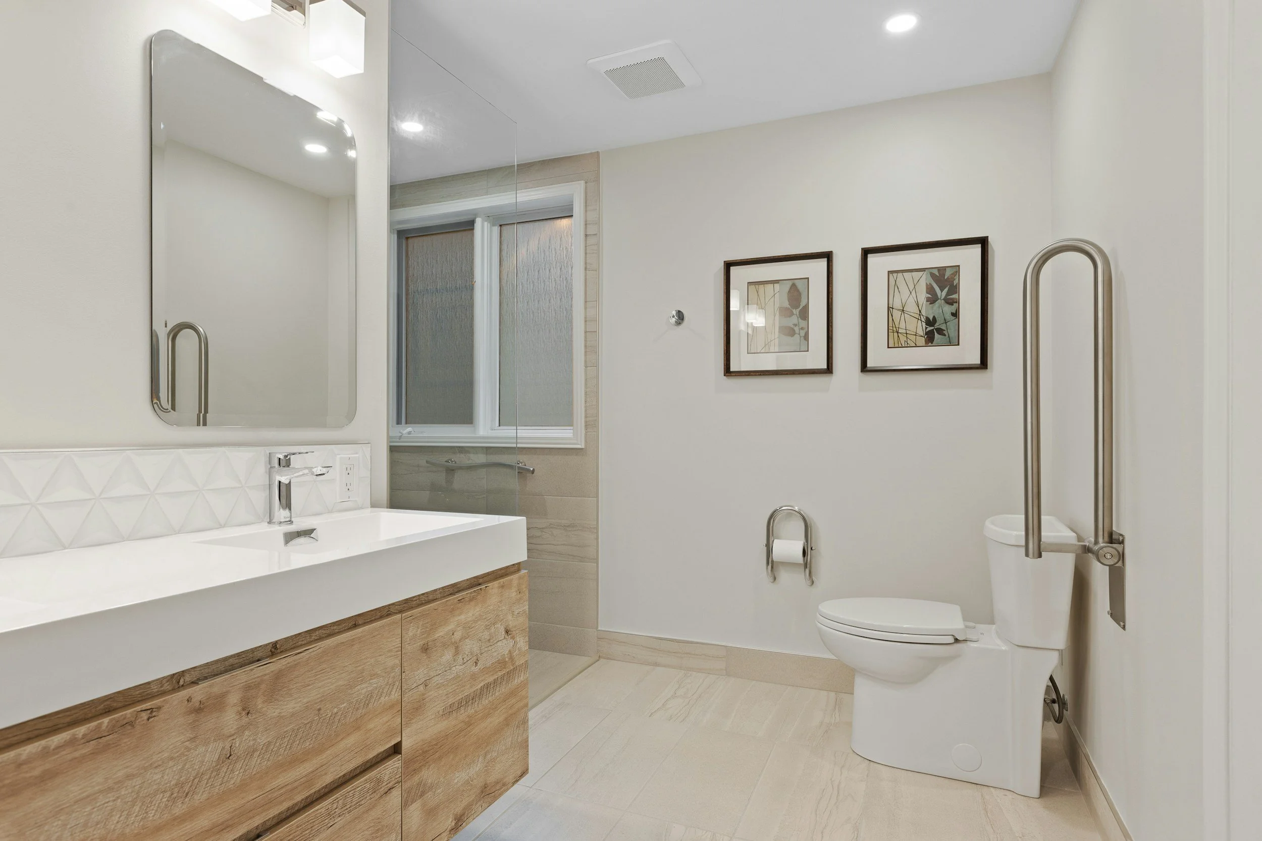 Accessible bathroom remodel in East Memphis featuring a walk-in shower, modern wood vanity, wide entry and strategically placed grab bars for aging in place.