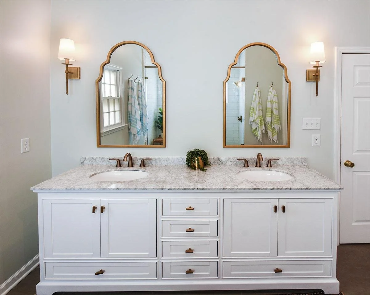 Arched mirrors, brass sconces, and clean white cabinetry create a balanced and refined look in this Germantown primary bathroom remodel.
