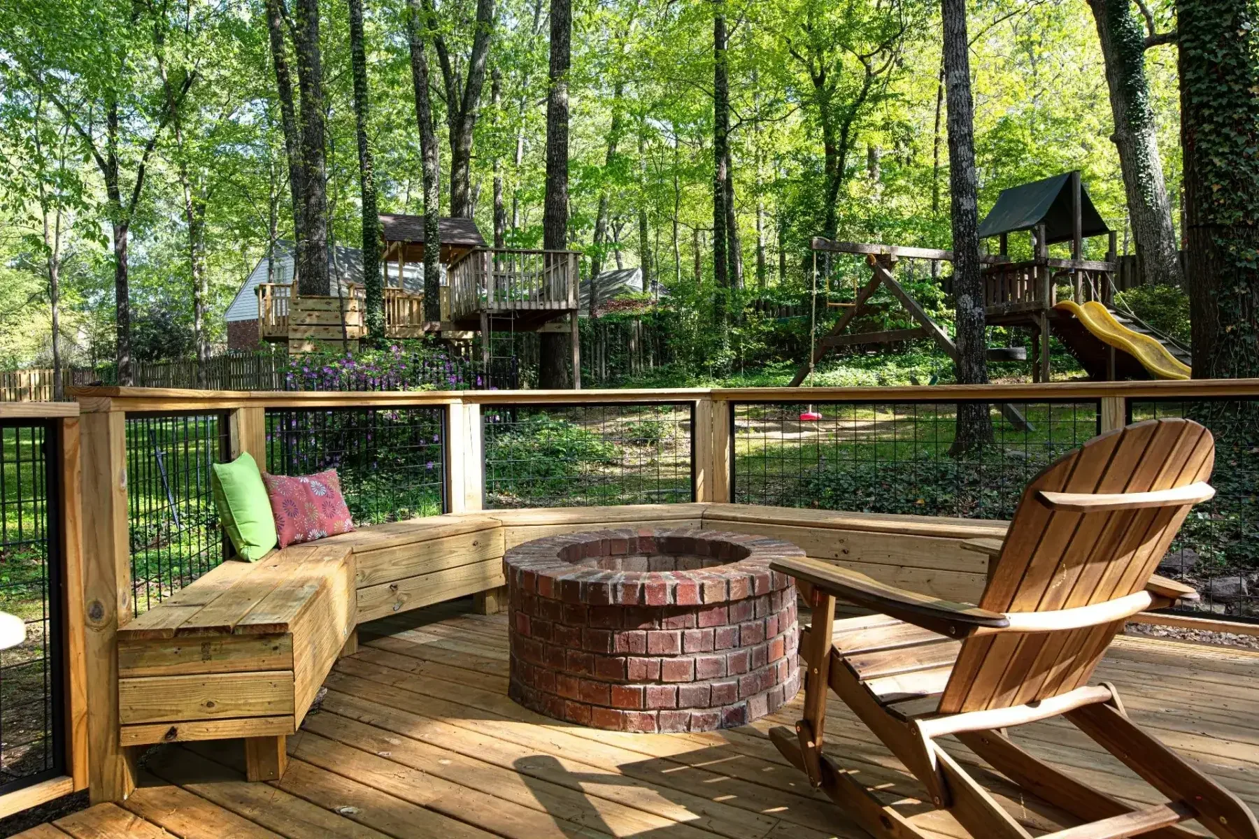 his elevated deck showcases sleek cable railing, built-in seating, and a central firepit, all designed to maximize views and functionality.