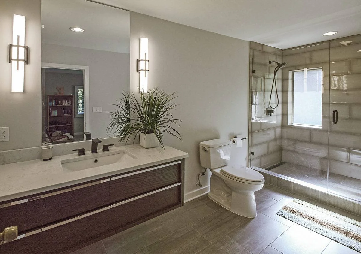 Modern bathroom vanity with dark wood cabinets, quartz countertop, and LED mirror in Memphis home remodel