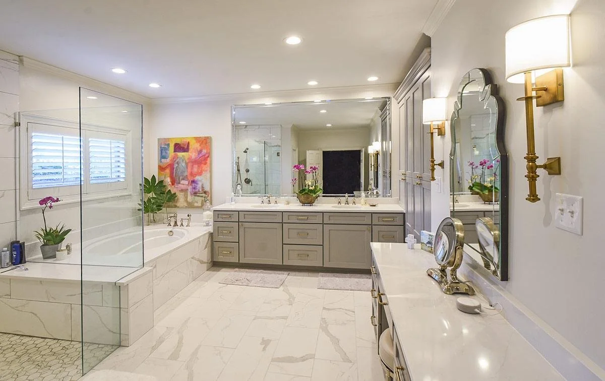 This expansive primary bathroom combines timeless finishes, custom cabinetry, and layered lighting to create a bright, luxurious retreat.