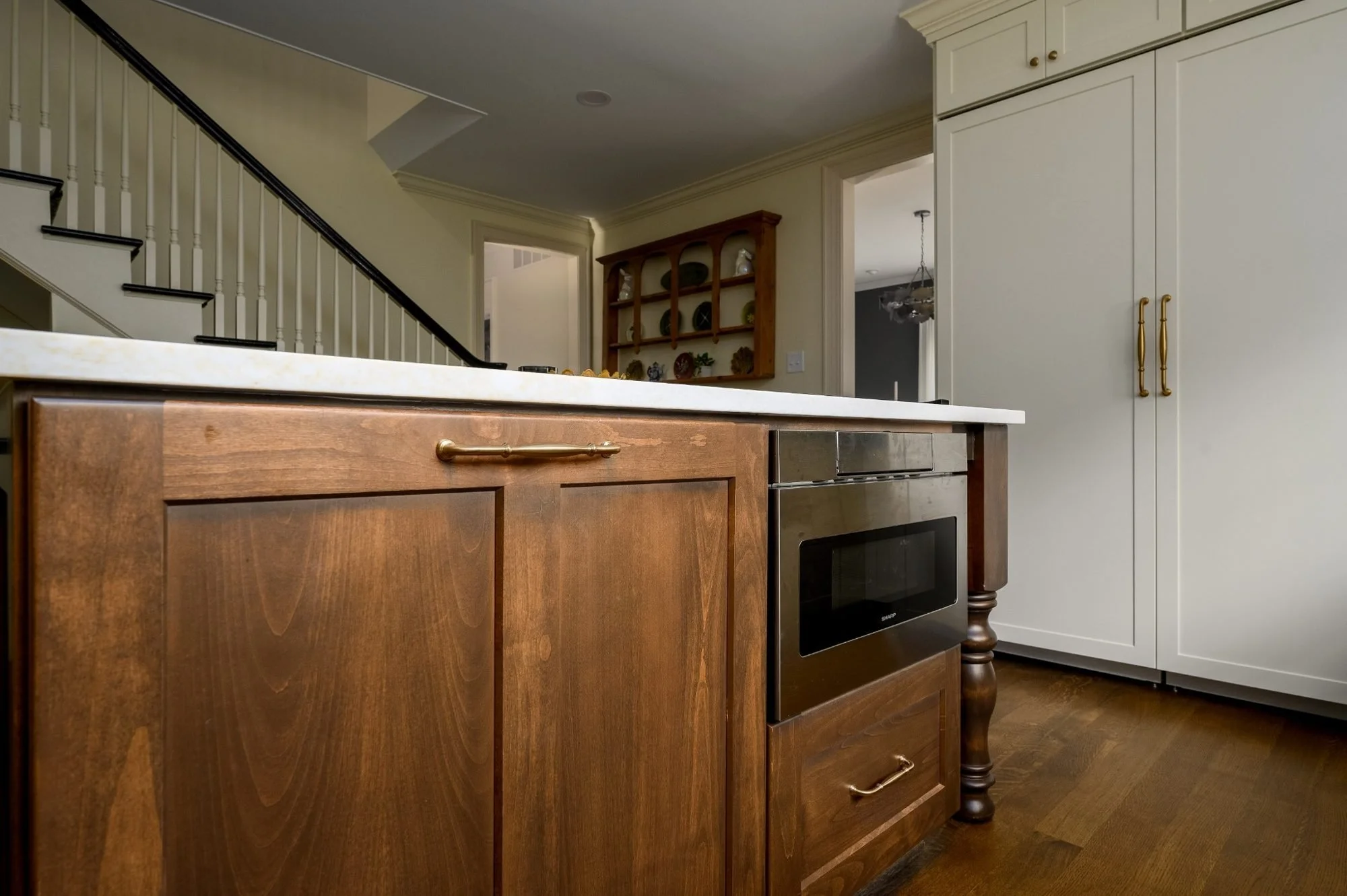 Warm wood kitchen island with built-in microwave and custom detailing