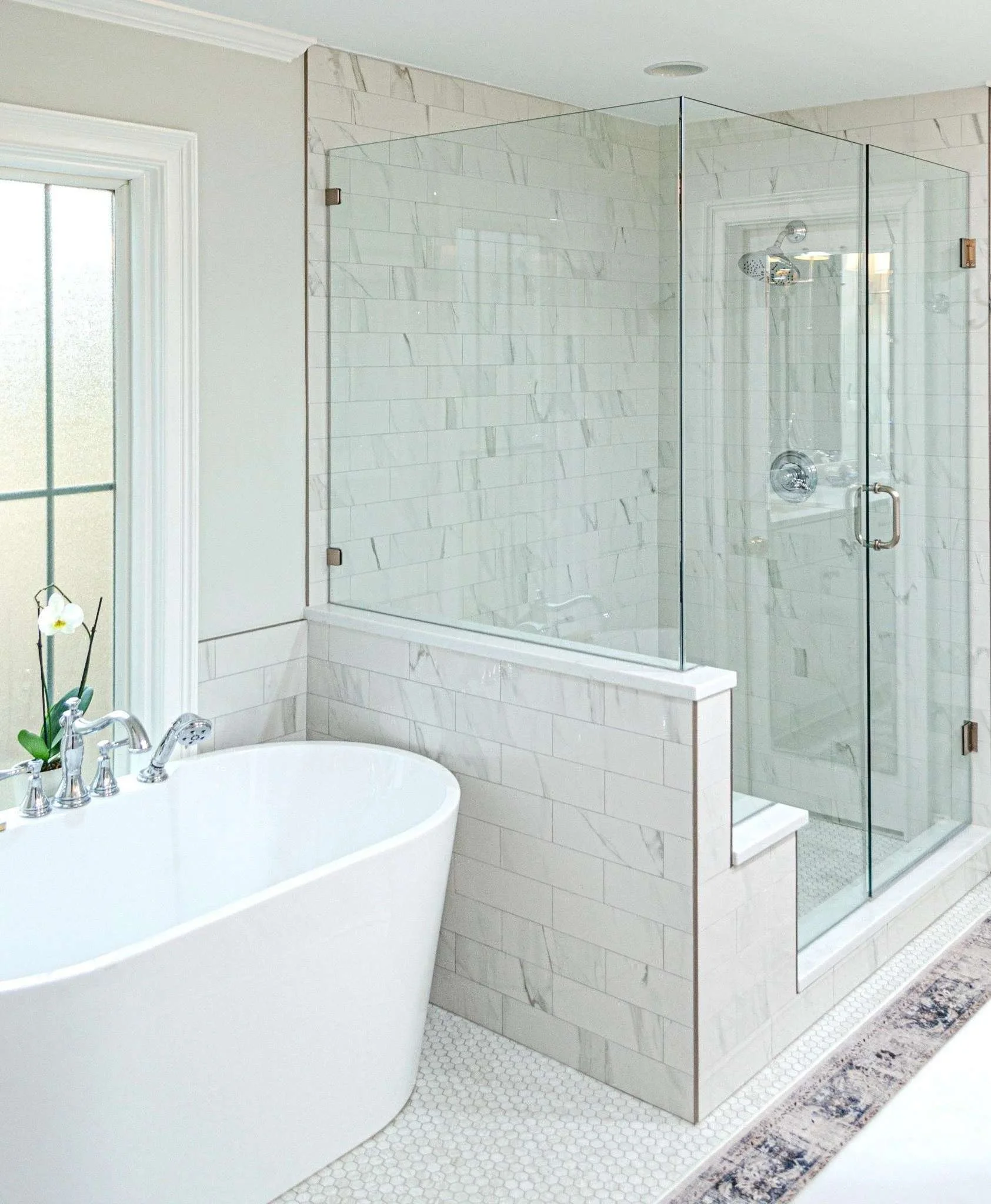 Luxury bathroom remodel in Germantown featuring a freestanding soaking tub, frameless glass shower, marble tile walls, and polished chrome fixtures.