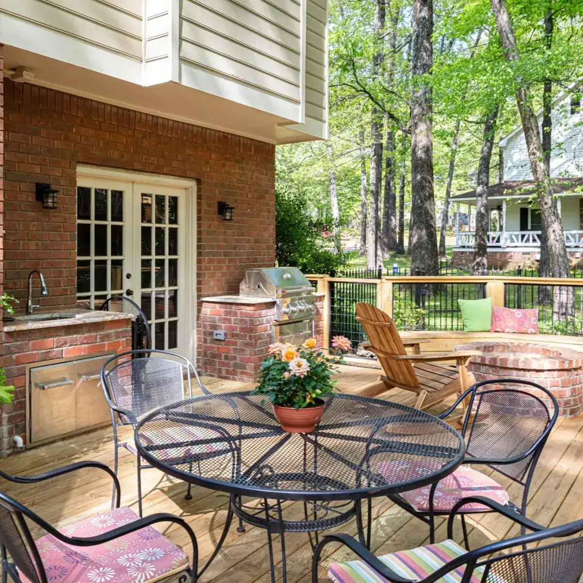 A custom wood deck in Collierville featuring a built-in brick firepit and bench seating, creating a warm and inviting space for outdoor gatherings.