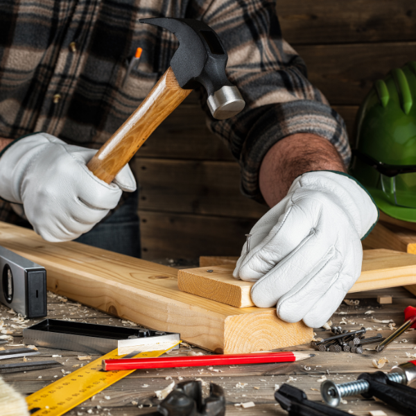 Handyman using a hammer to nail two-by-four lumber together while completing a residential carpentry project for Robbins Construction Home Services in Memphis, Tennessee.