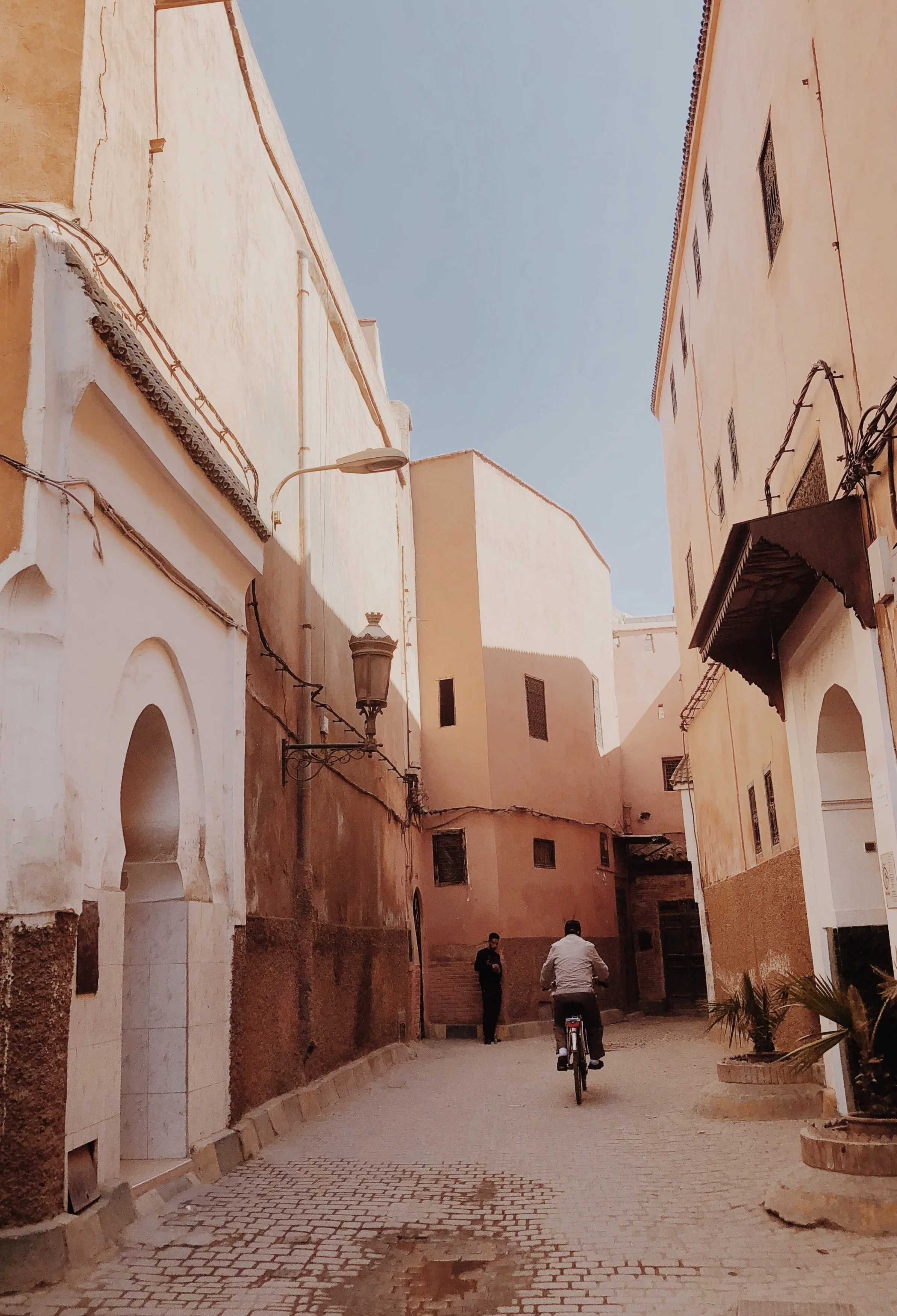 man riding a bike through Morocco alley