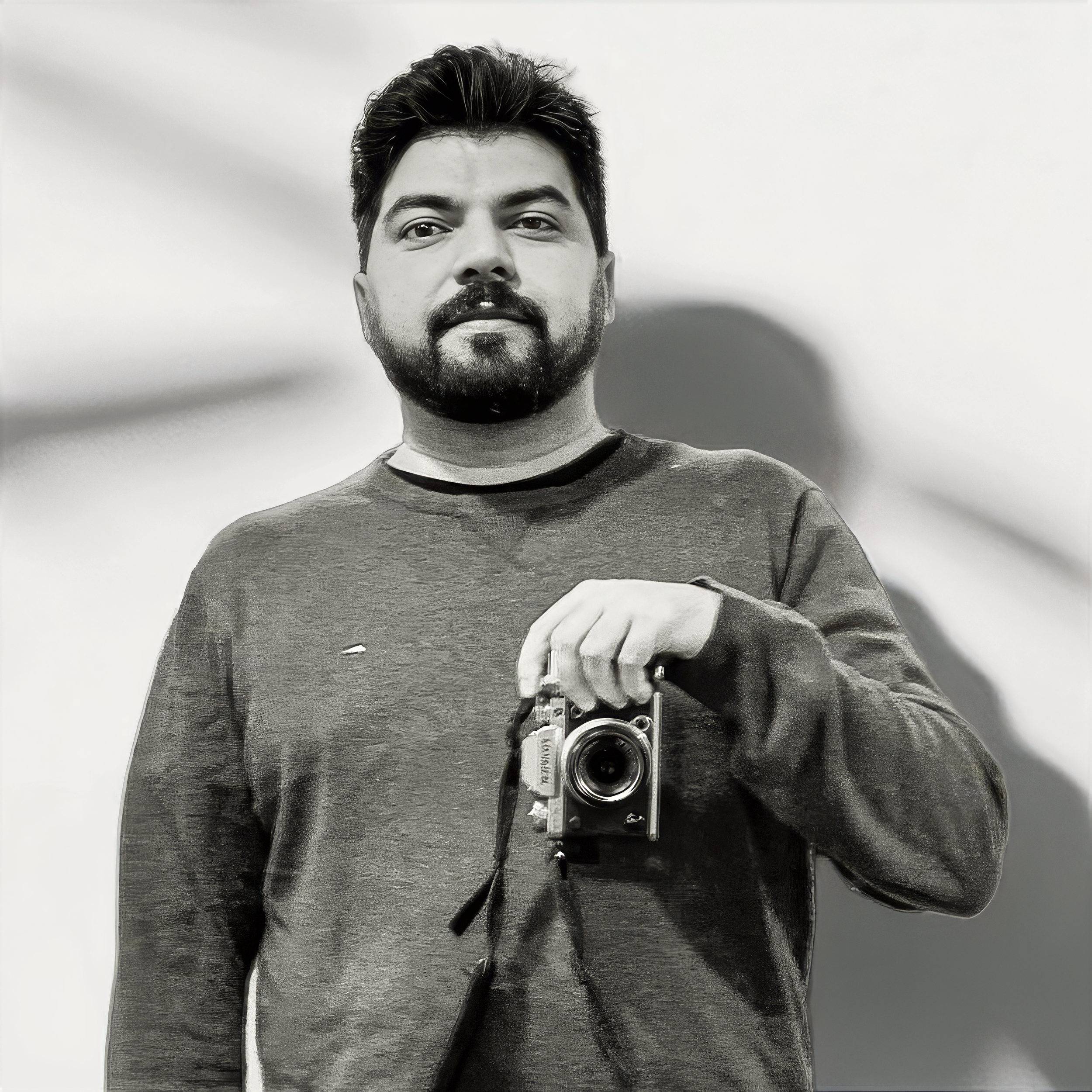 Portrait of Erfanomous, visual storyteller and filmmaker, holding a camera.