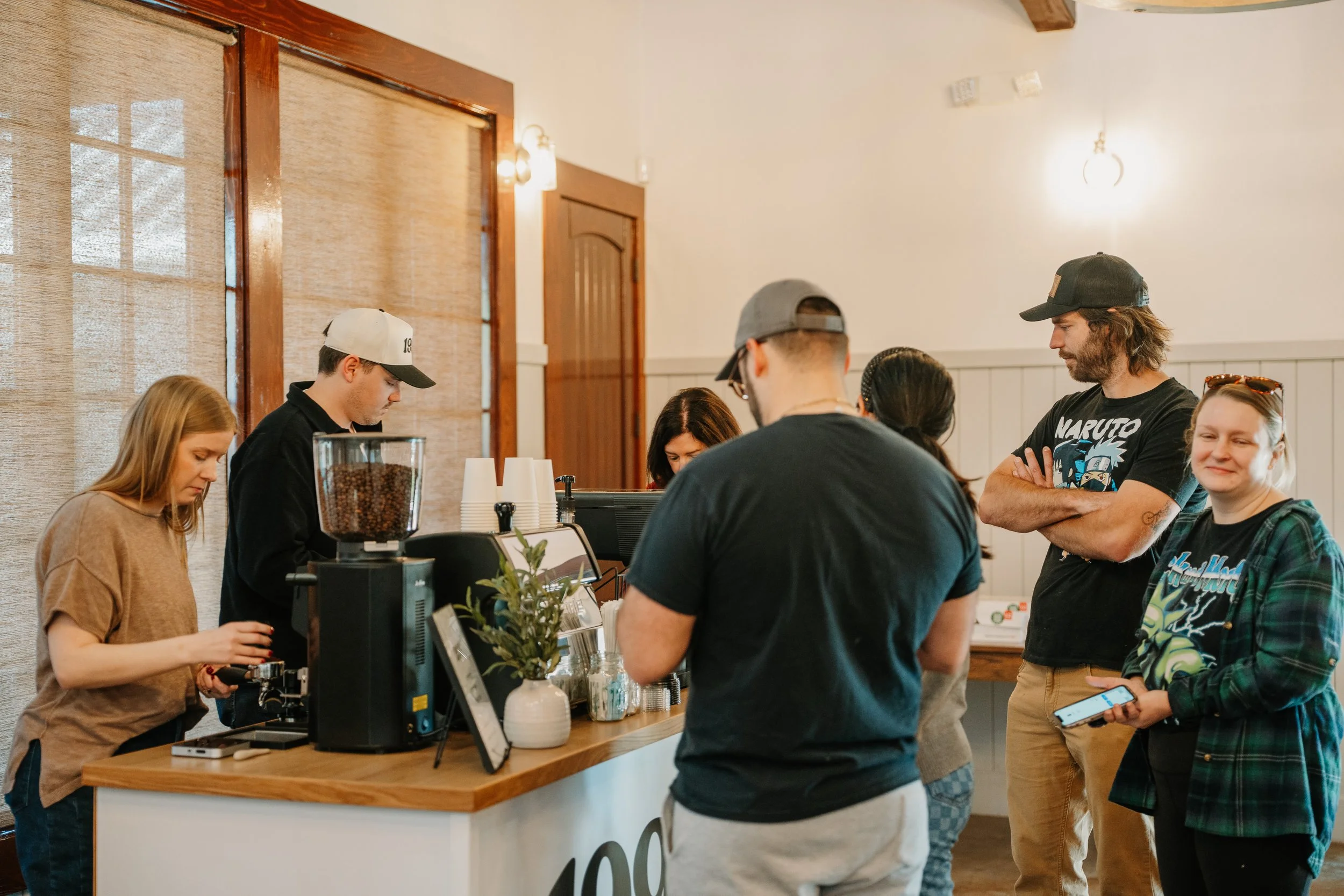 customers waiting for their drinks in front of cart while baristas are behind it making drinks