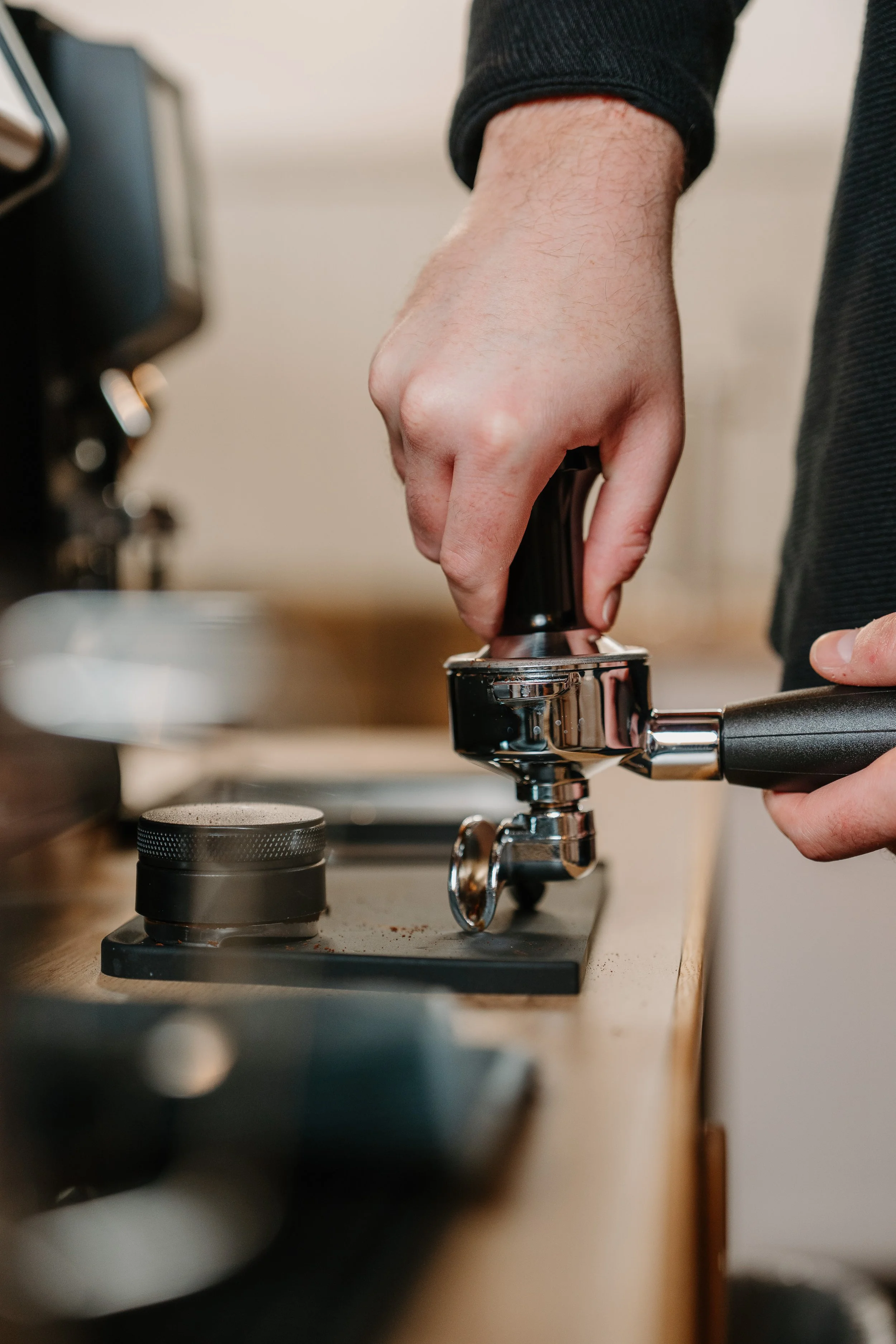 Barista tamping espresso shot in San Marcos