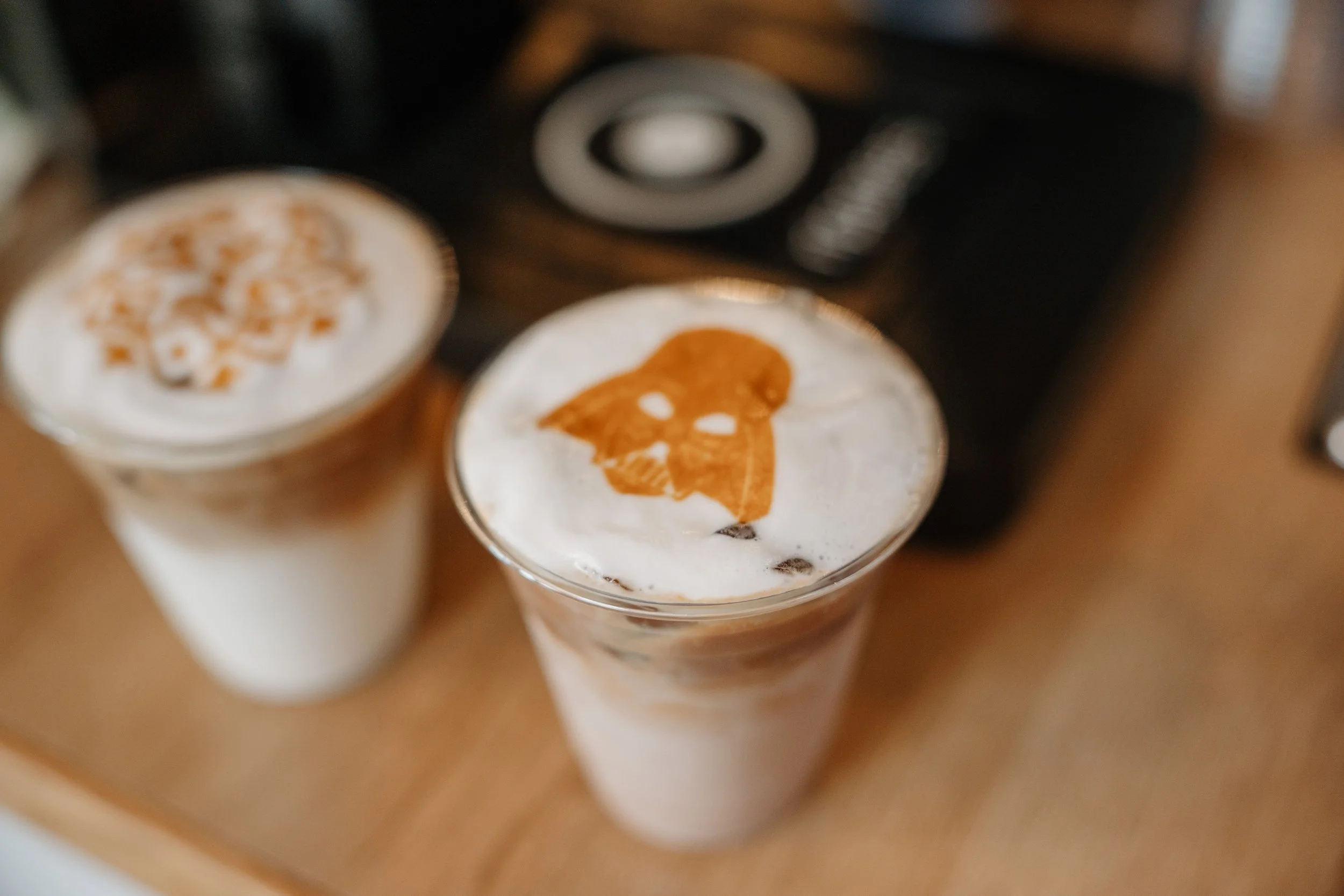 two iced lattes showing cool darth vader latte art