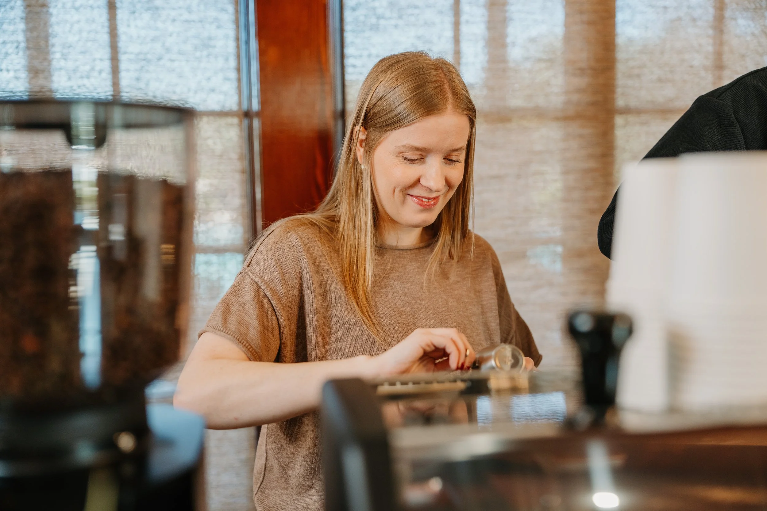 Barista smiling while pouring a shot of espresso