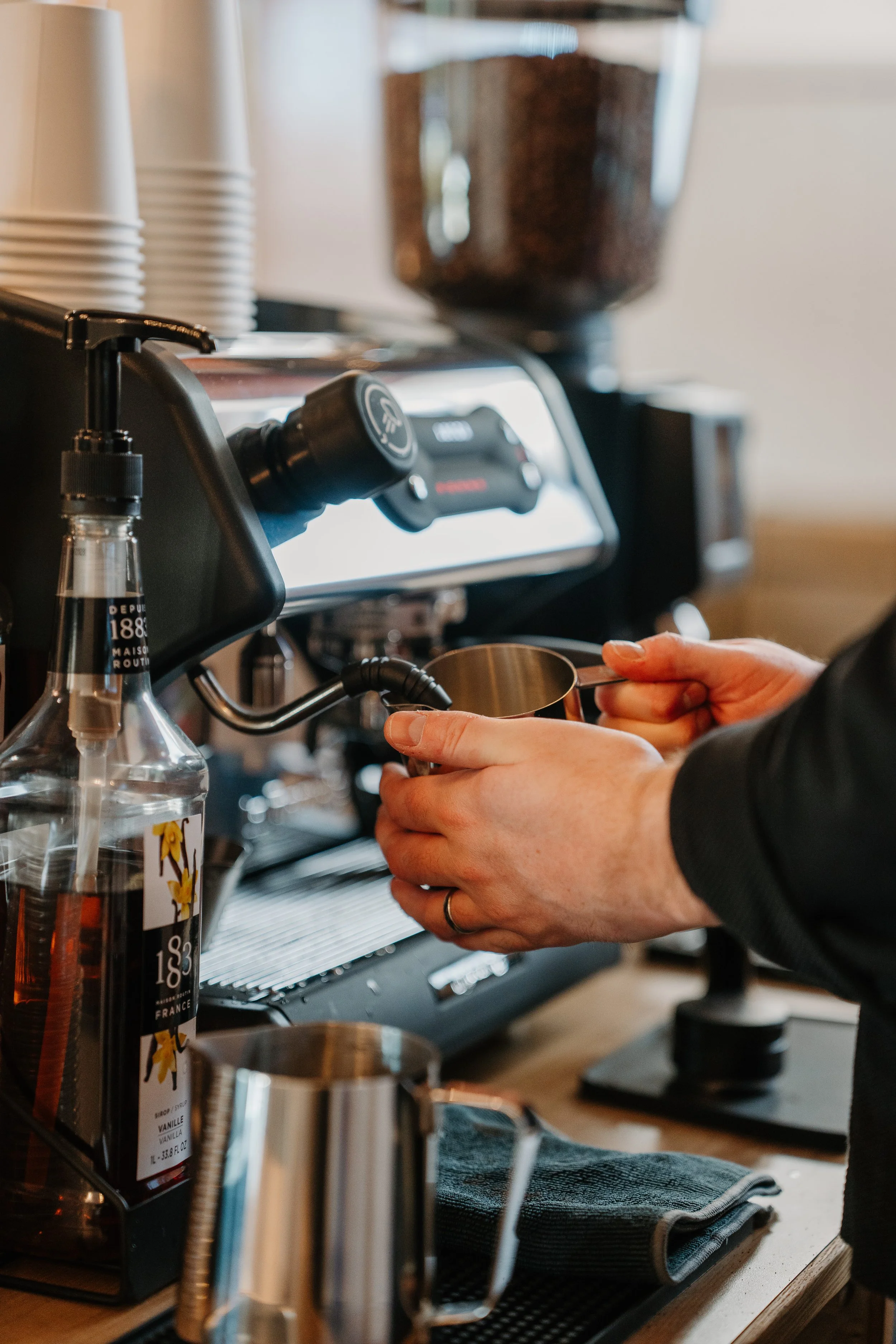 barista steaming milk behind espresso bar in Buda
