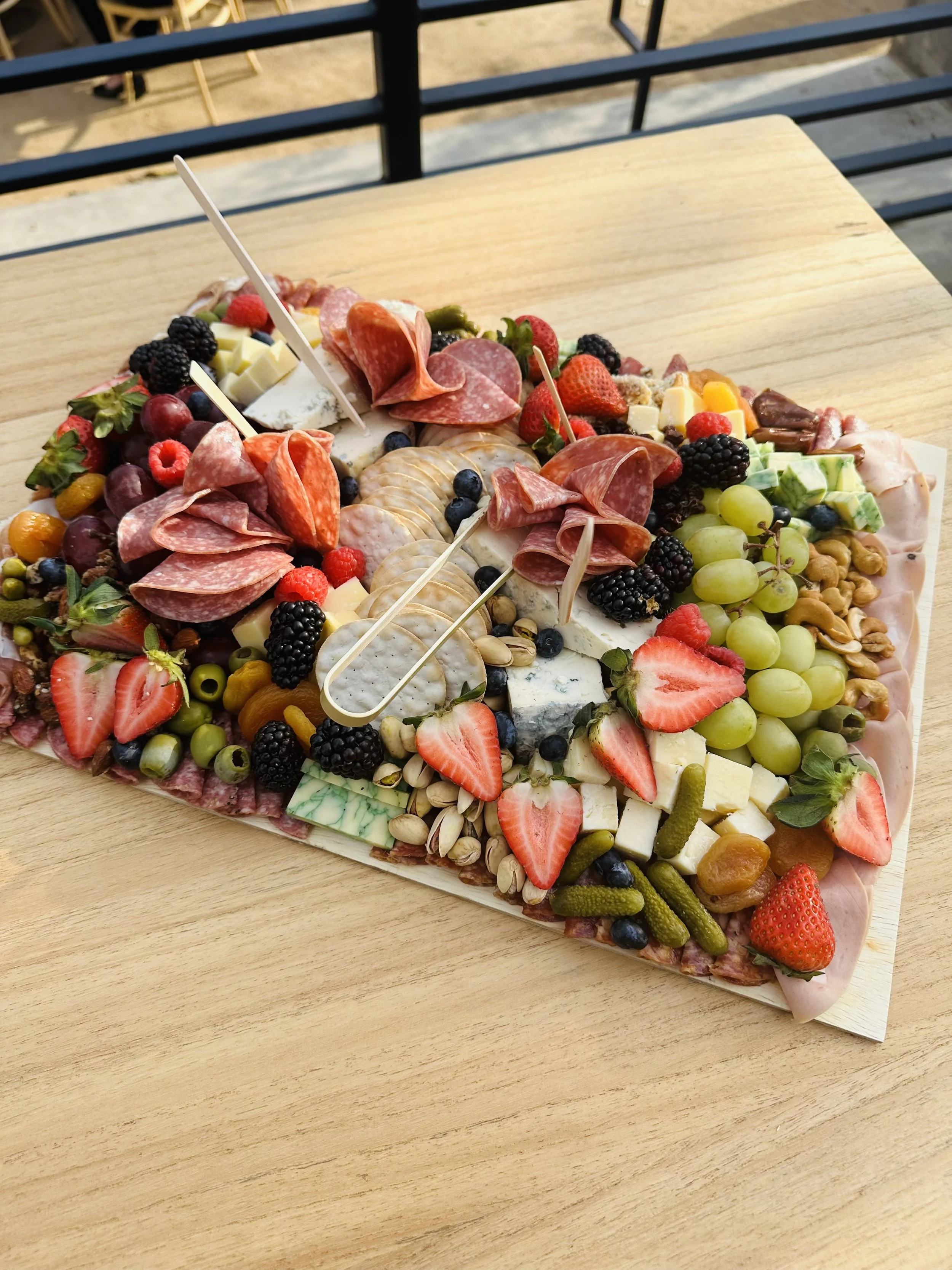 Artisan charcuterie board with cheeses, cured meats, fruit, and nuts prepared by Olive Wood Pizza catering