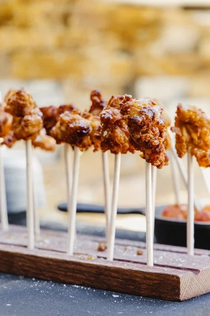 Buttermilk fried chicken lollipops served on skewers at an Olive Wood Pizza event
