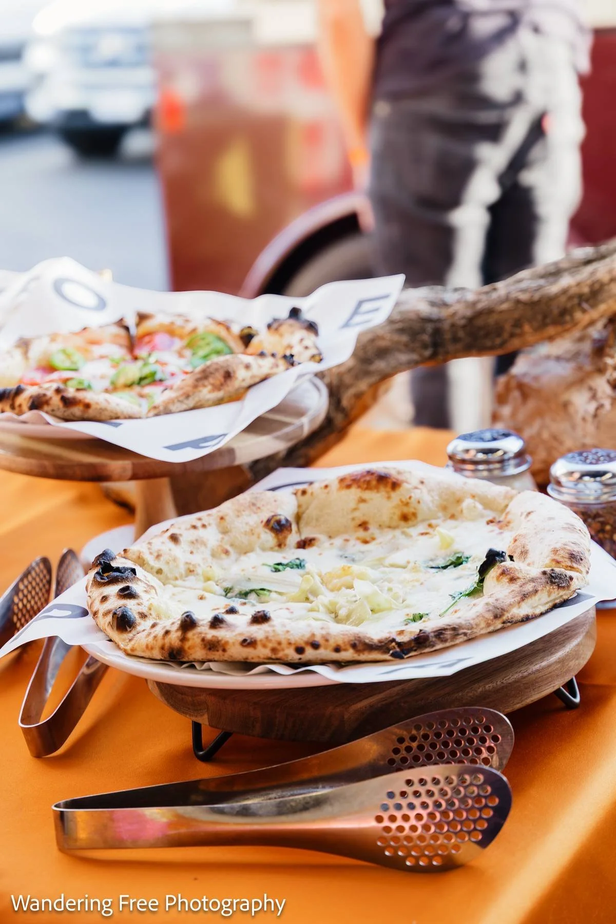 Wood-fired pizzas served outdoors on a table at an Olive Wood Pizza catered event