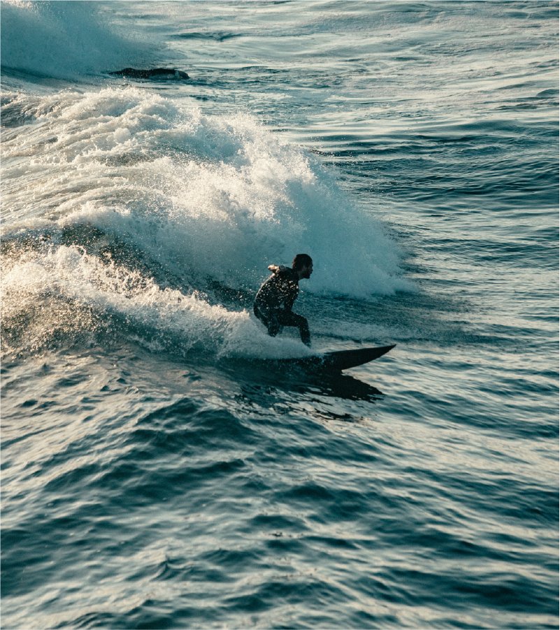 A person surfing on a wave in the ocean during daytime.