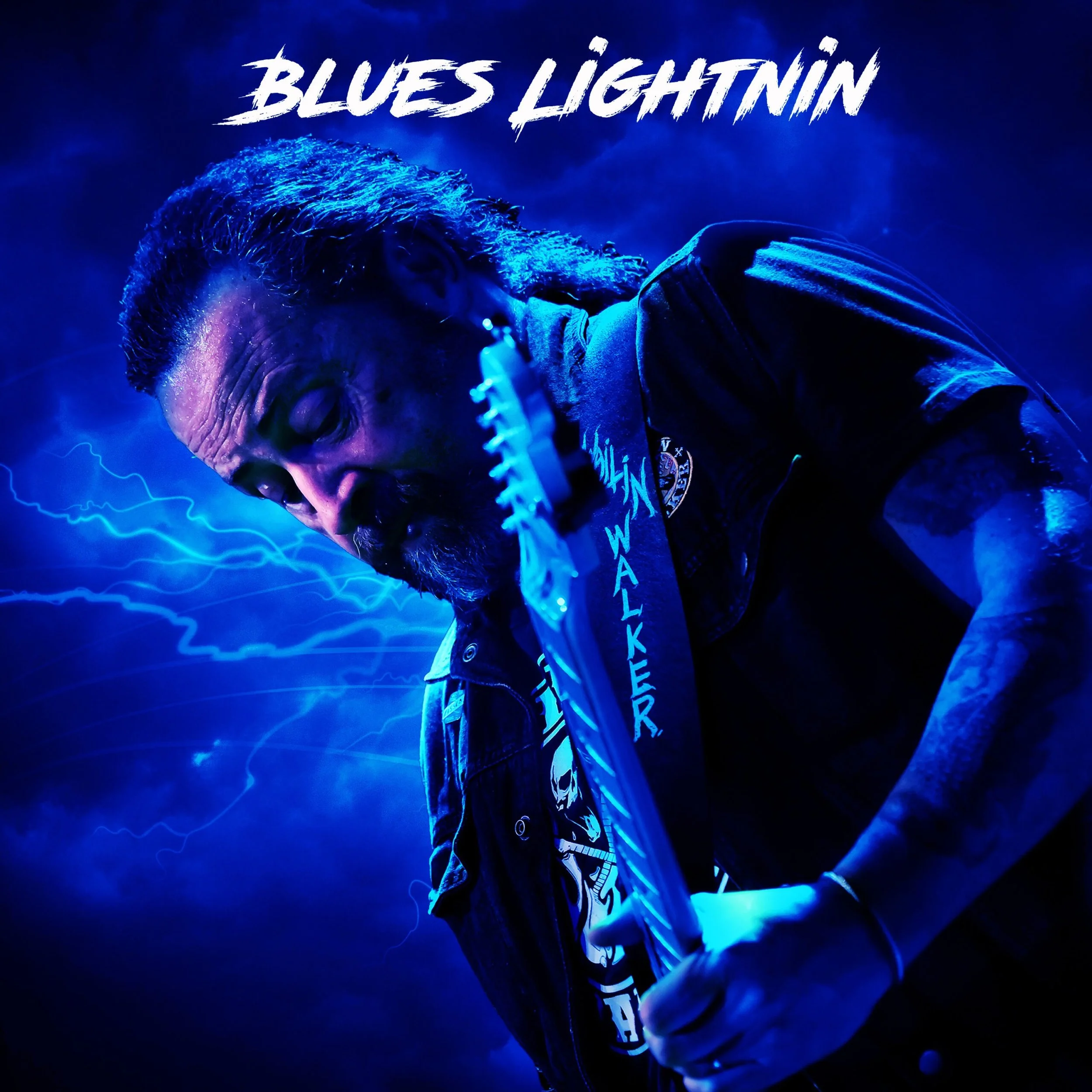 Ein Mann mit langem Haar und Bart, der eine E-Gitarre spielt, in einer dunklen, bläulichen Szene mit Blitzen im Hintergrund, trägt ein knielanges T-Shirt und eine Jacke, mit dem Text 'Blues Lightning' oben.
