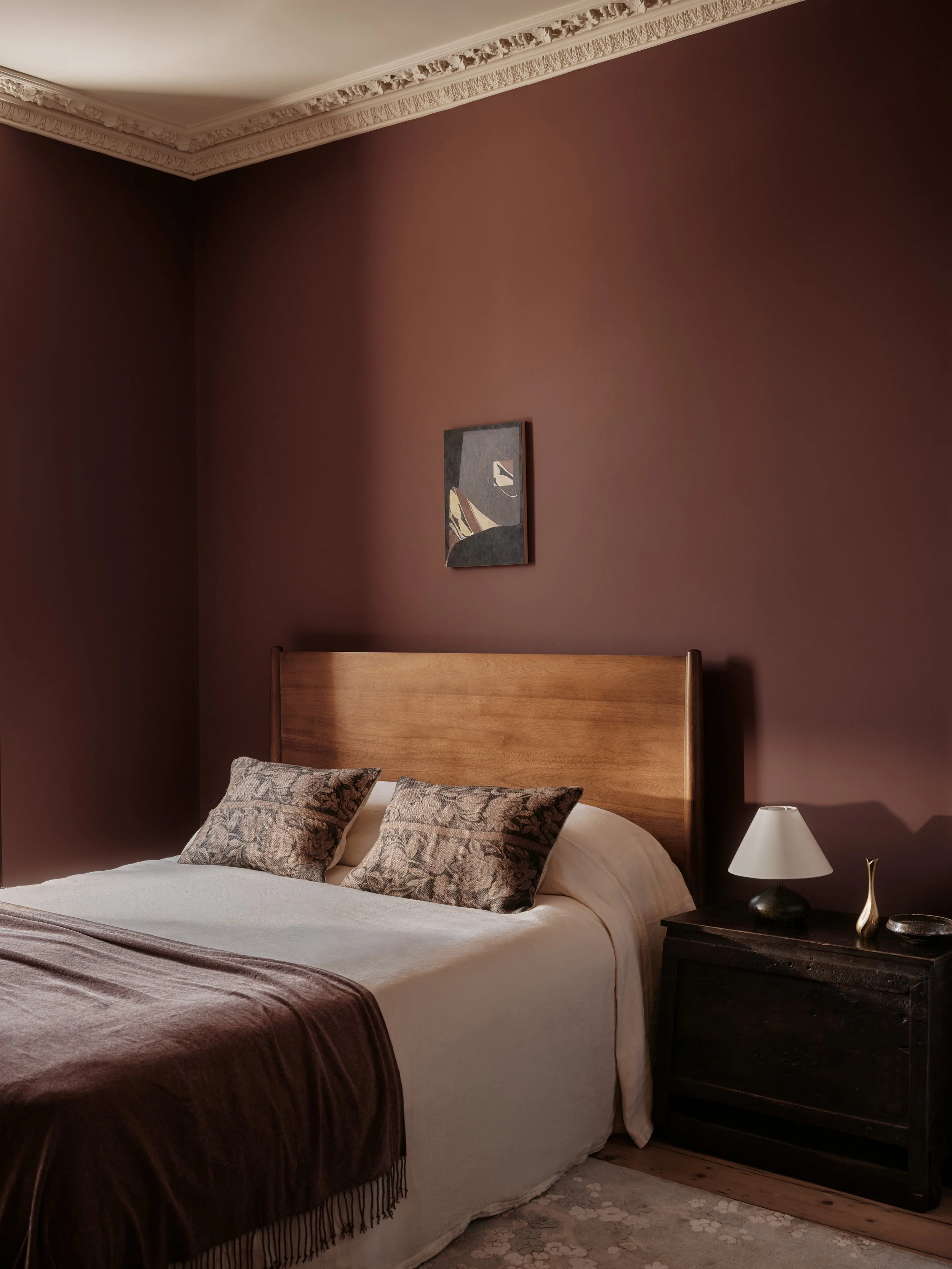 High end interior designed bedroomwith atmospheric lighting and rich colours and textiles, campaign photography by Ryan Handy for Farrow and Ball.