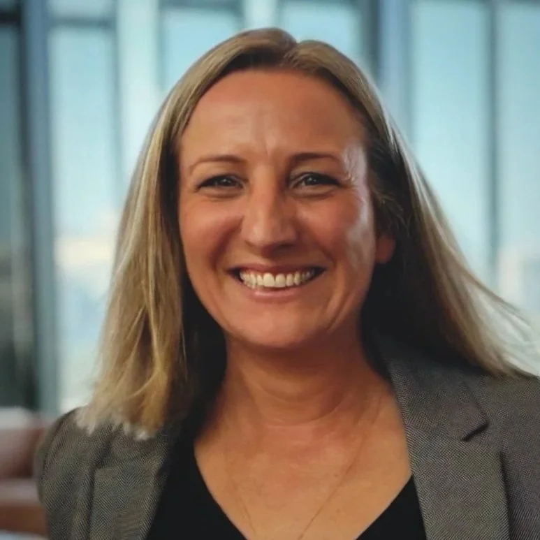 Photograph of Leighann Smiling at the Camera Wearing a Grey Jacket