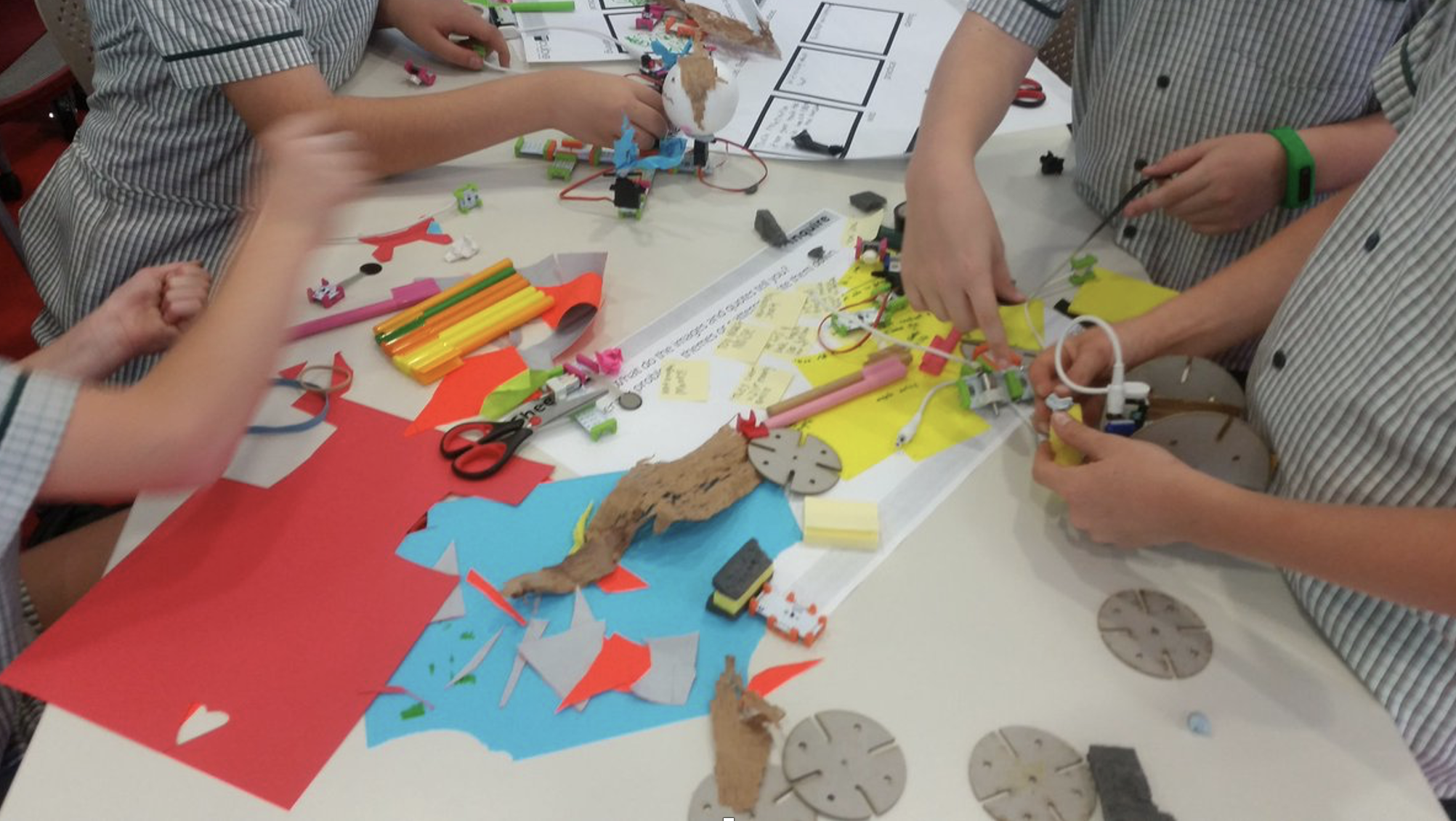 Photograph of school students working at a creative workshop table