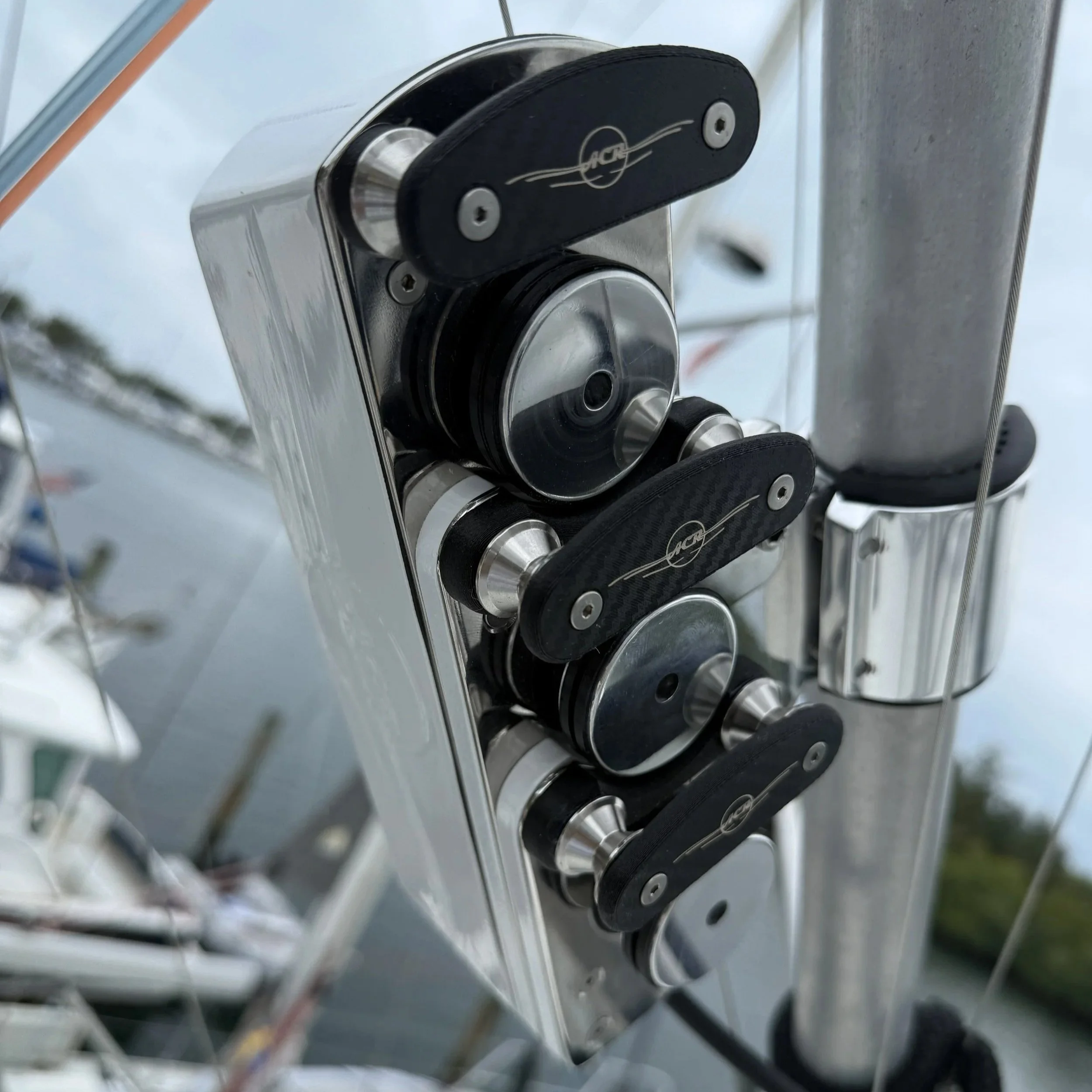 Multiple fishing rods are mounted on a boat, with the ocean and sky in the background.