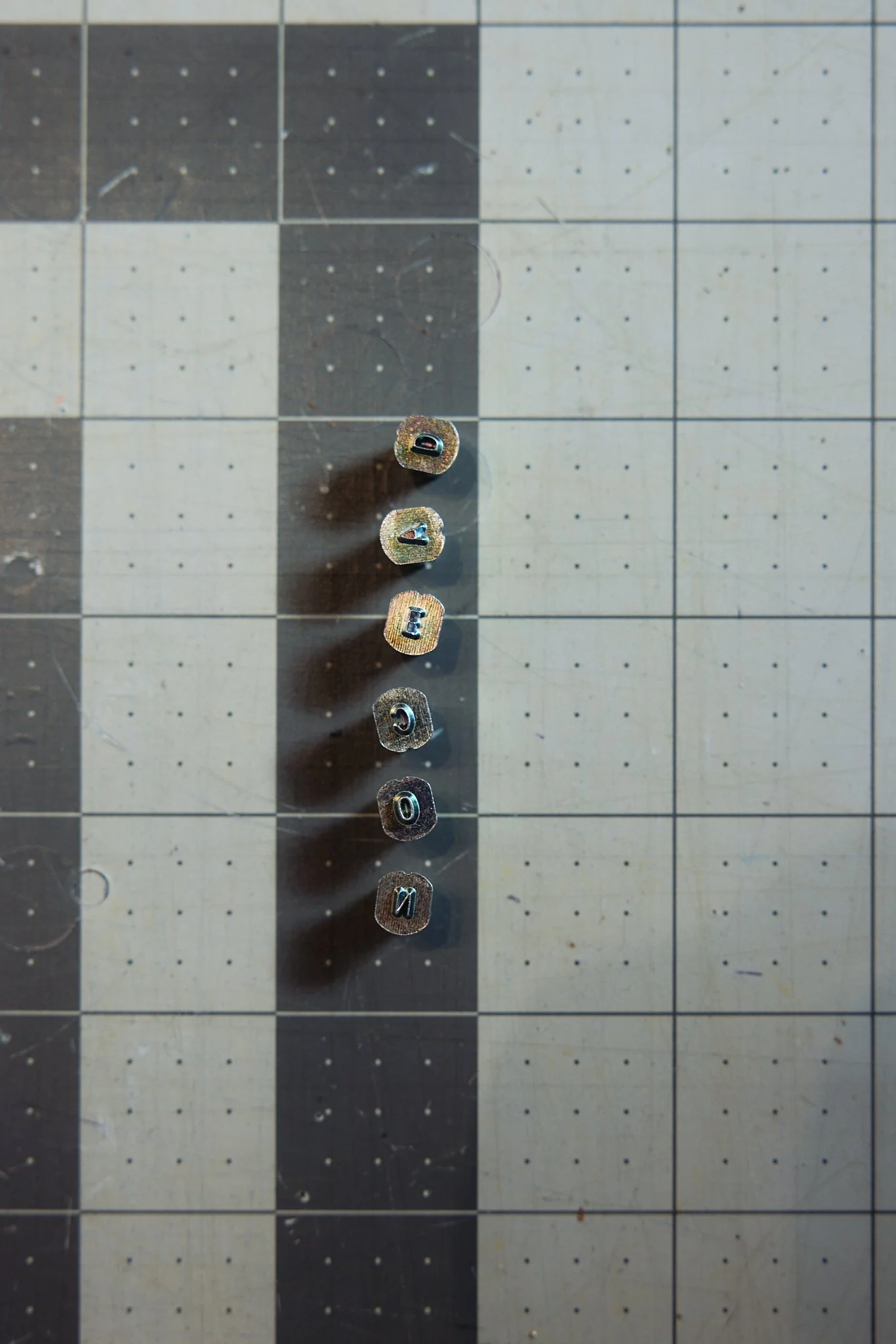 Metal letter dice arranged vertically on a grid surface spelling 'DATA CODE'.