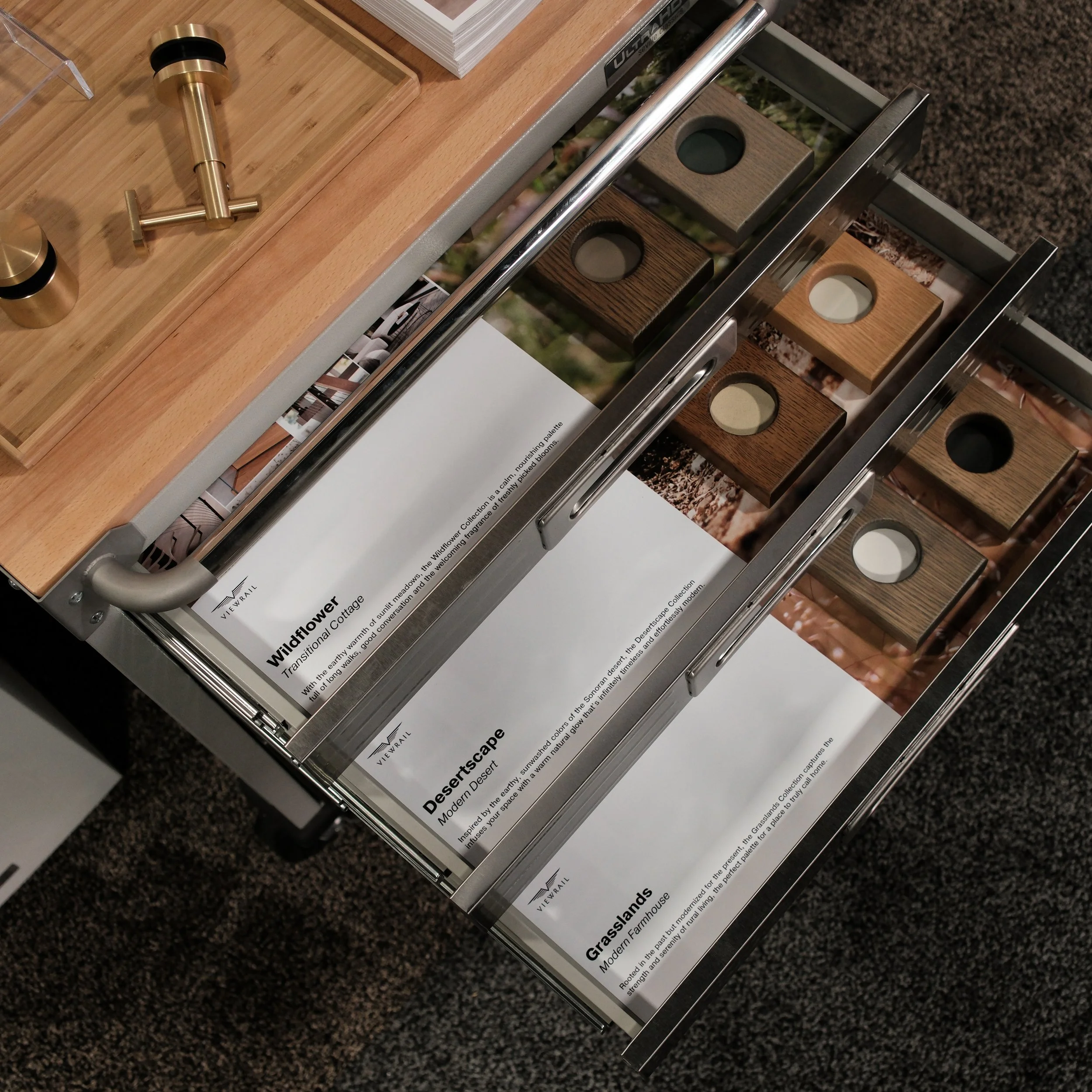 Open drawer displaying samples of wood finishes and colors labeled as Wildflower, Desertsacpe, and Grasslands.