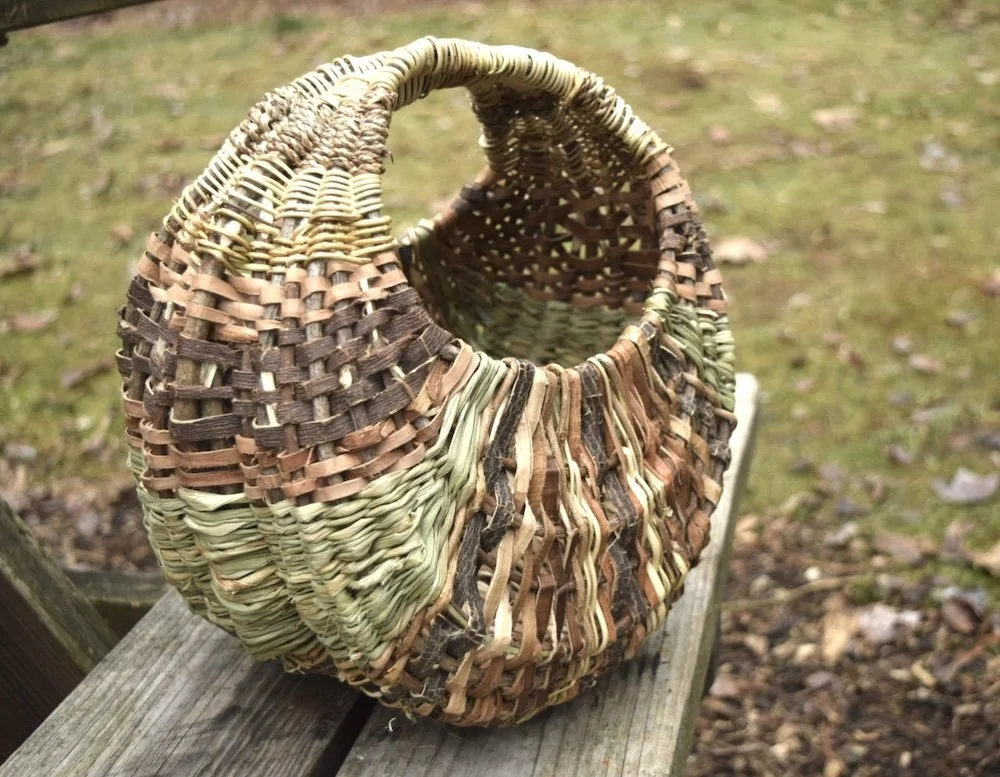 a ribbed basket made with vines, bark, and cattails