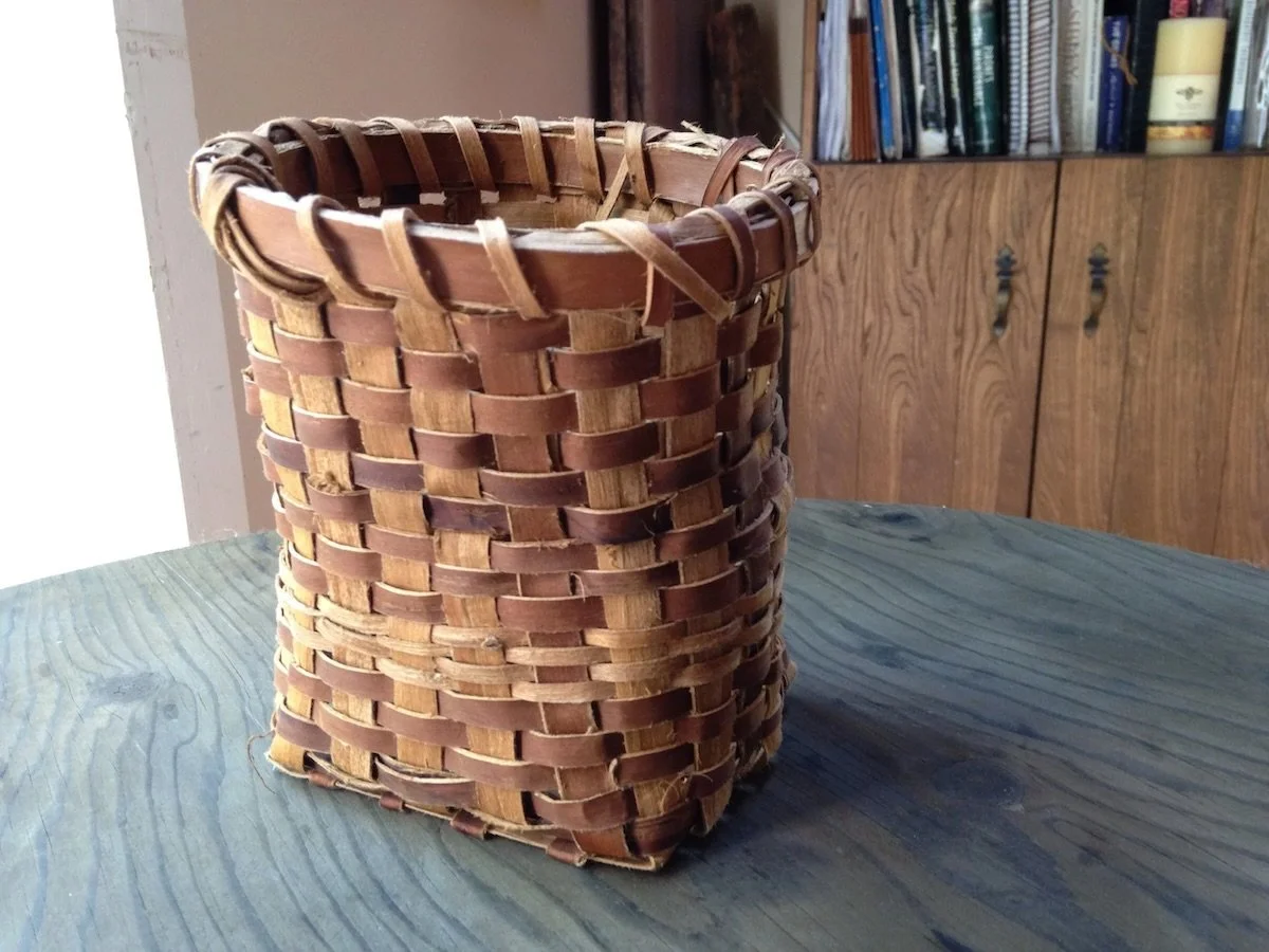 a woven elm bark basket sitting on a table