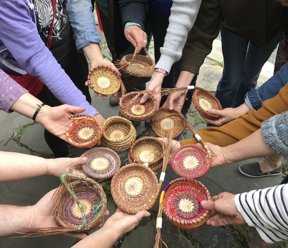 hands in a basket weaving workshop holding pine needle baskets