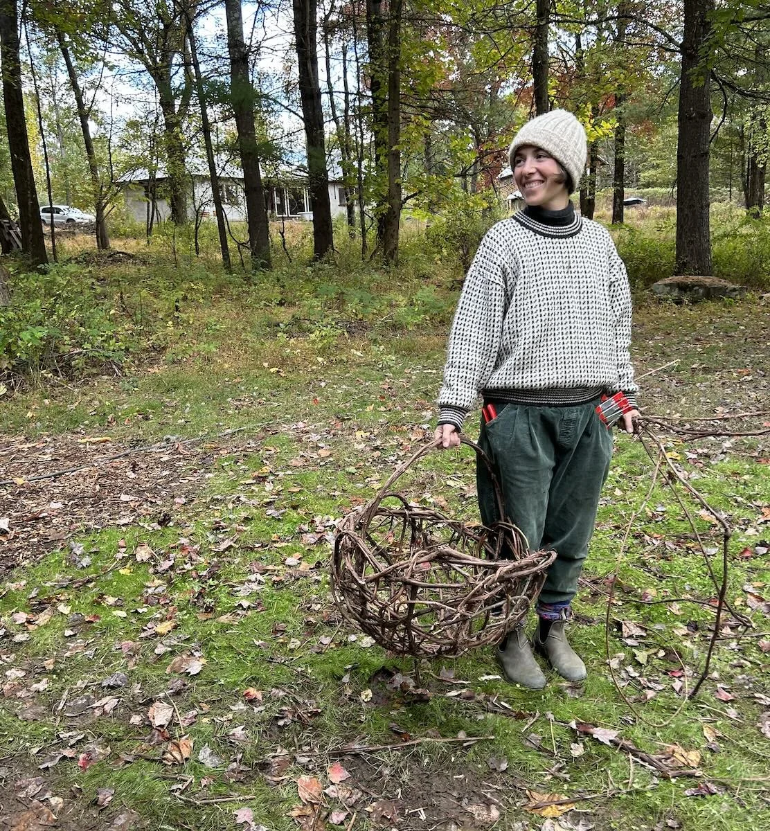a woman holding a vine basket in a field