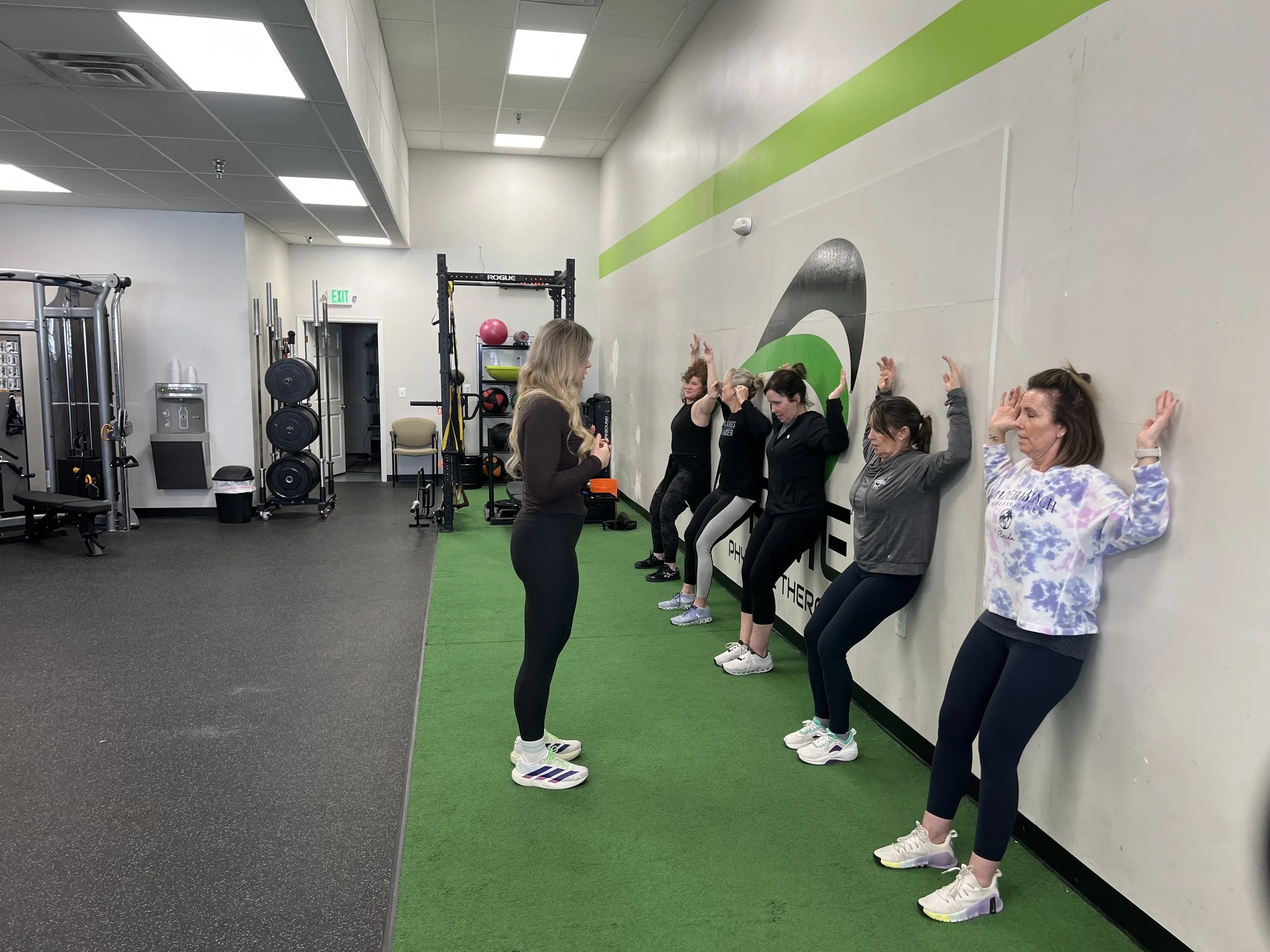 Group stretching and activating muscles during the Sweat Crawl kickoff at a physical therapy space