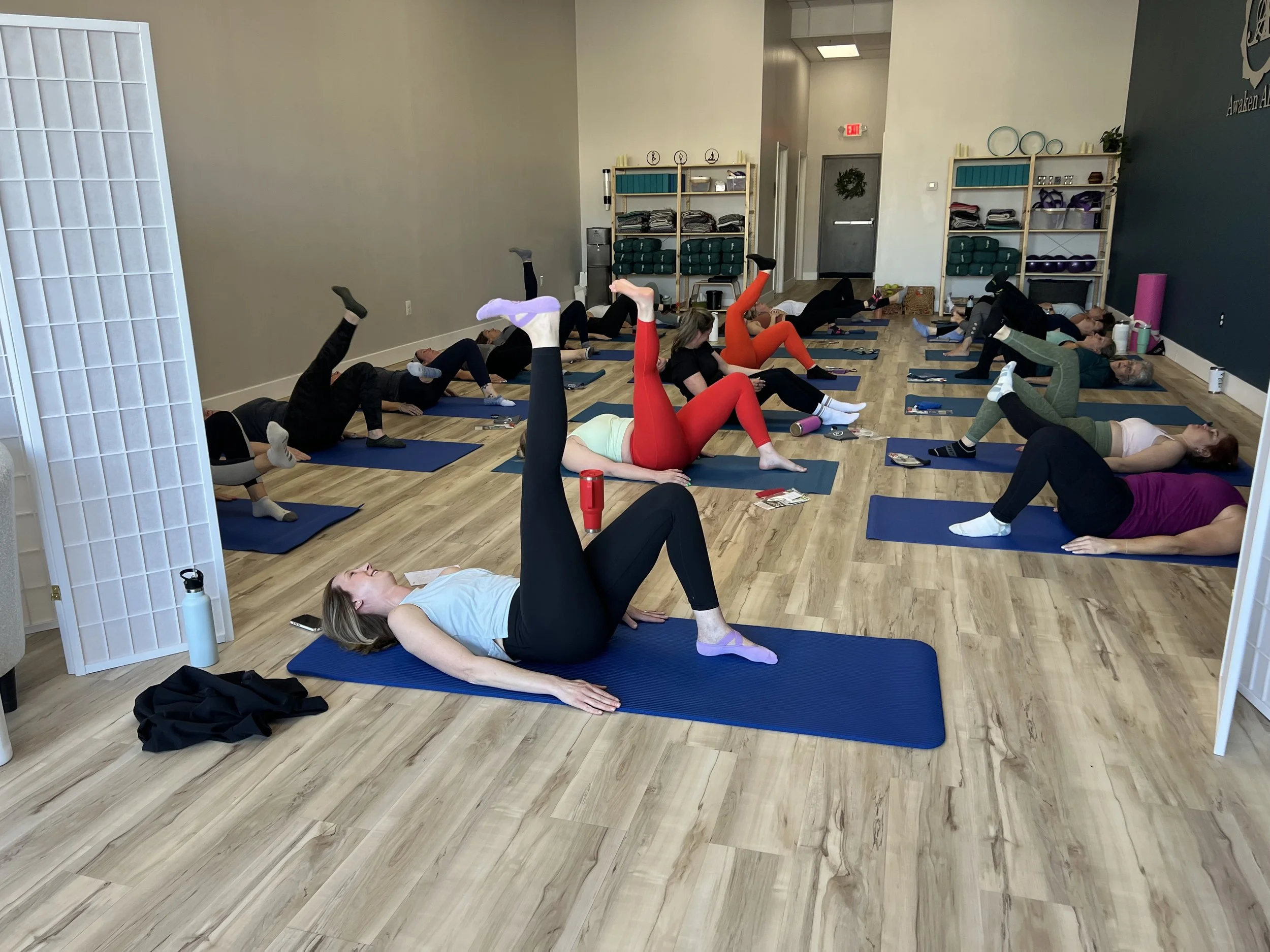 Women practicing mindful movement and breathwork during a Sweat Crawl yoga session