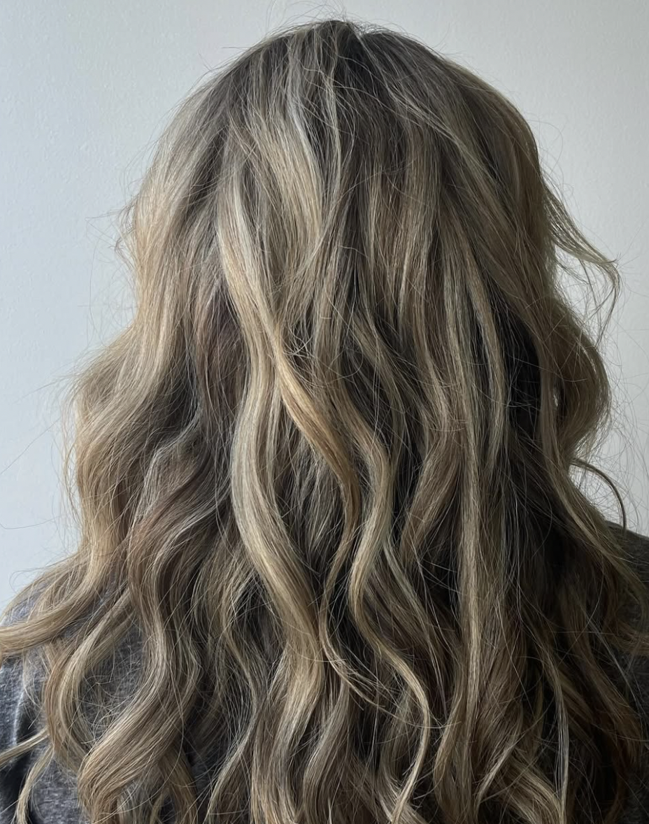 Back view of wavy, blonde hair with darker roots.