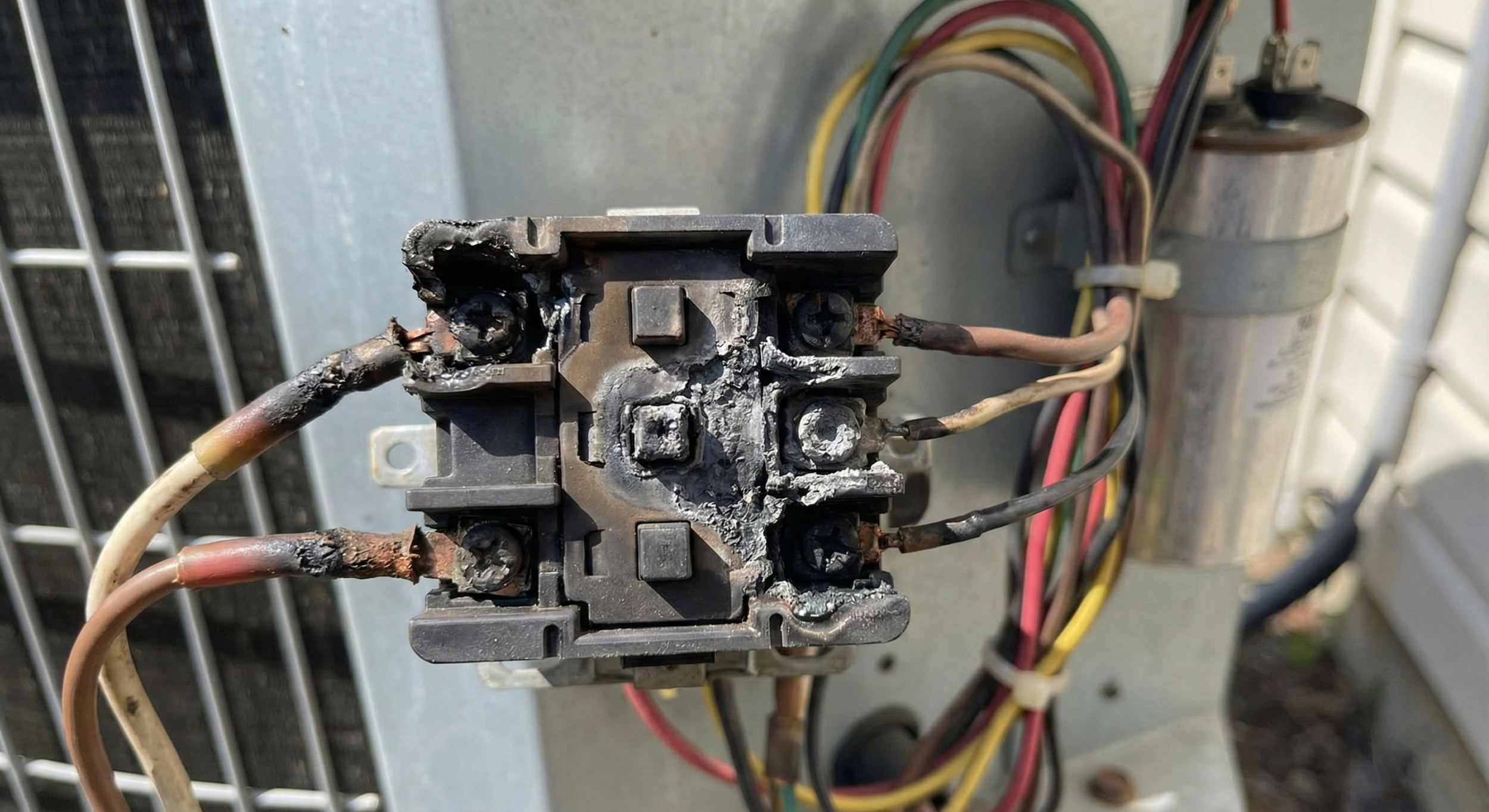 Close-up of hvac troubleshooting process showing a technician measuring voltage at a contactor with a professional hvac diagnostic chart for reference