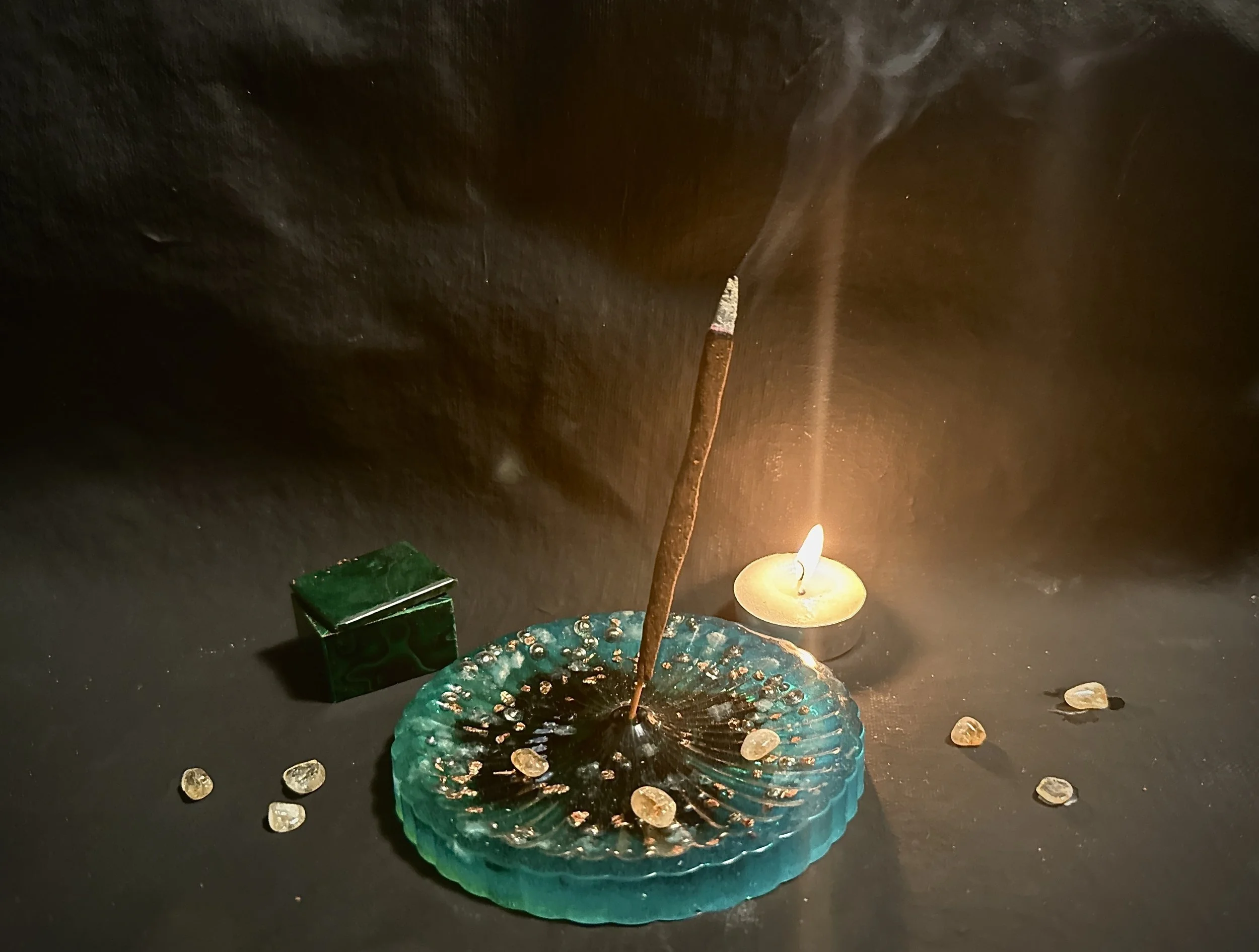 Handcrafted ritual incense burning beside a tea light in a sacred space prepared for meditation and spiritual practice by Charles Decáte