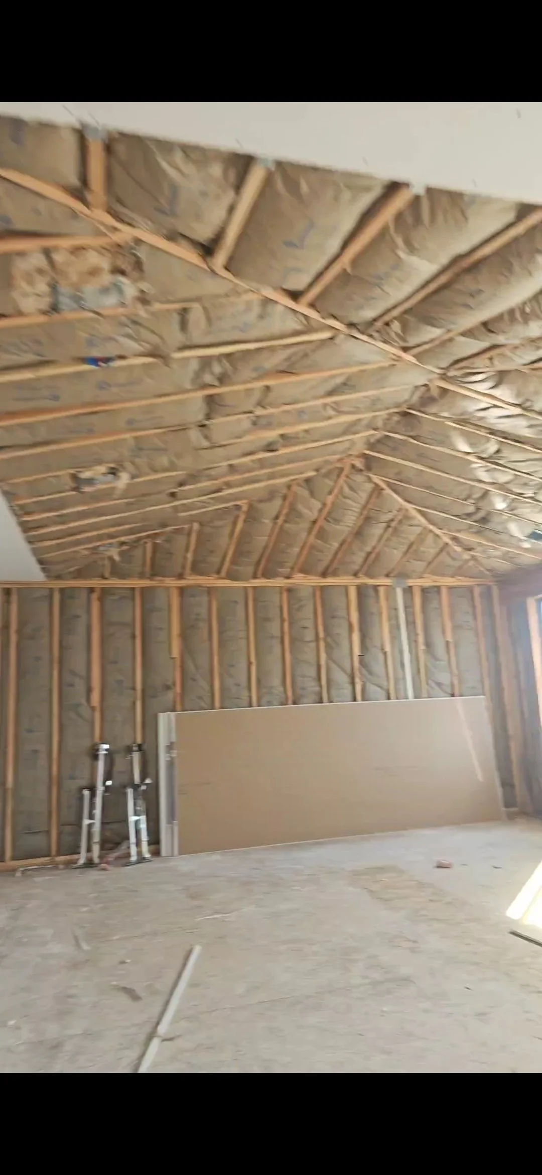 Techo en construcción con aislamiento y estructura de madera en una habitación.