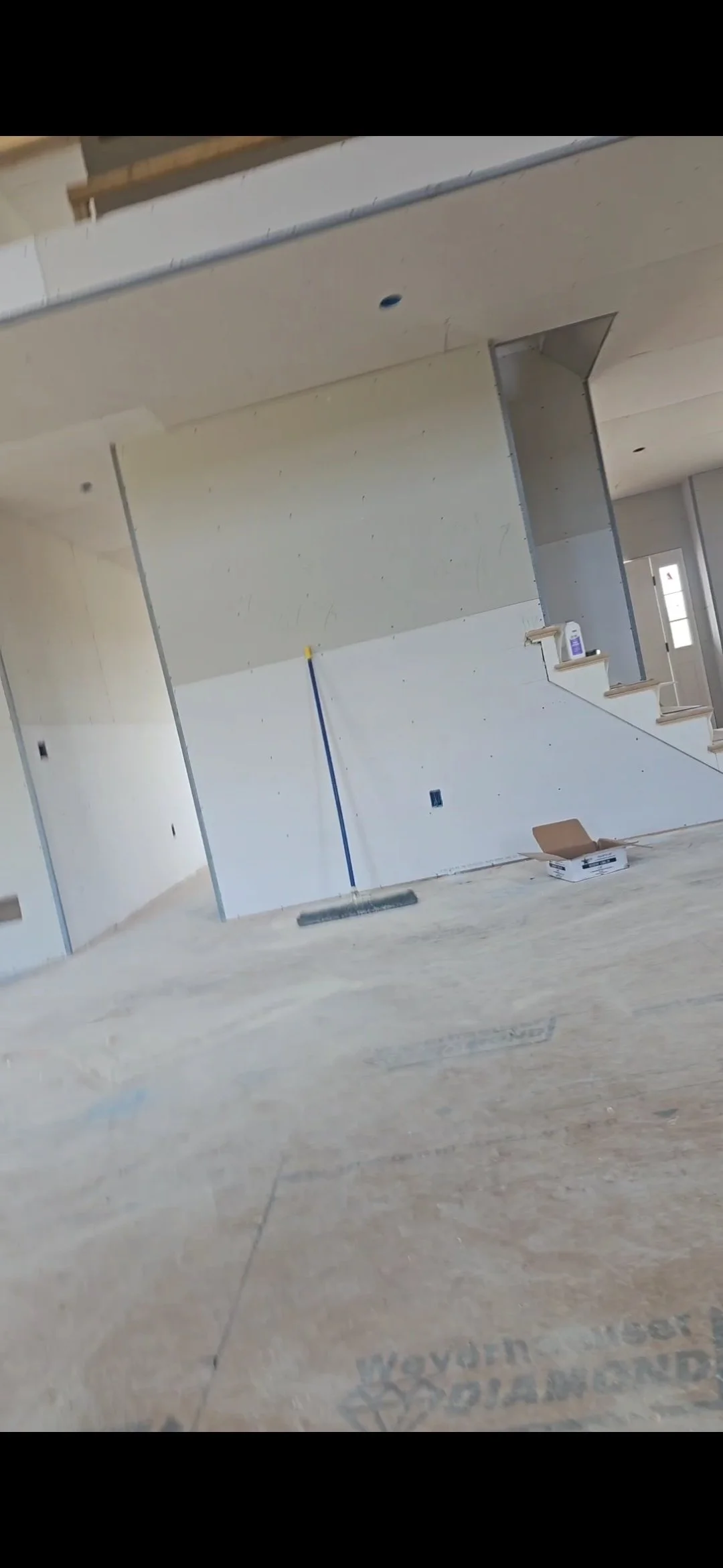 Interiores de una casa en construcción con paredes y piso en proceso de acabado, sin muebles ni decoraciones.