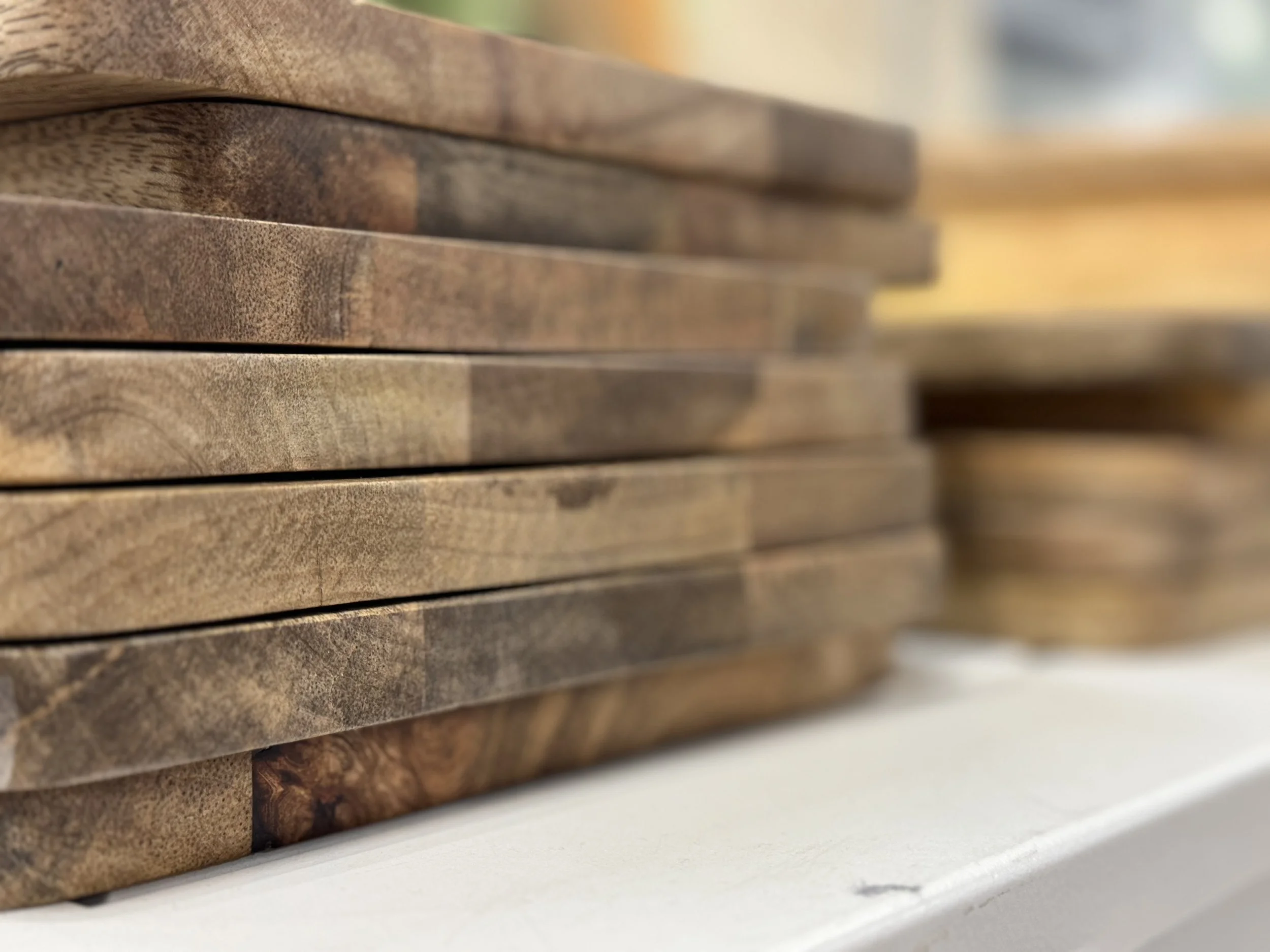 Close-up of a stack of wooden planks or tiles placed on a white surface.