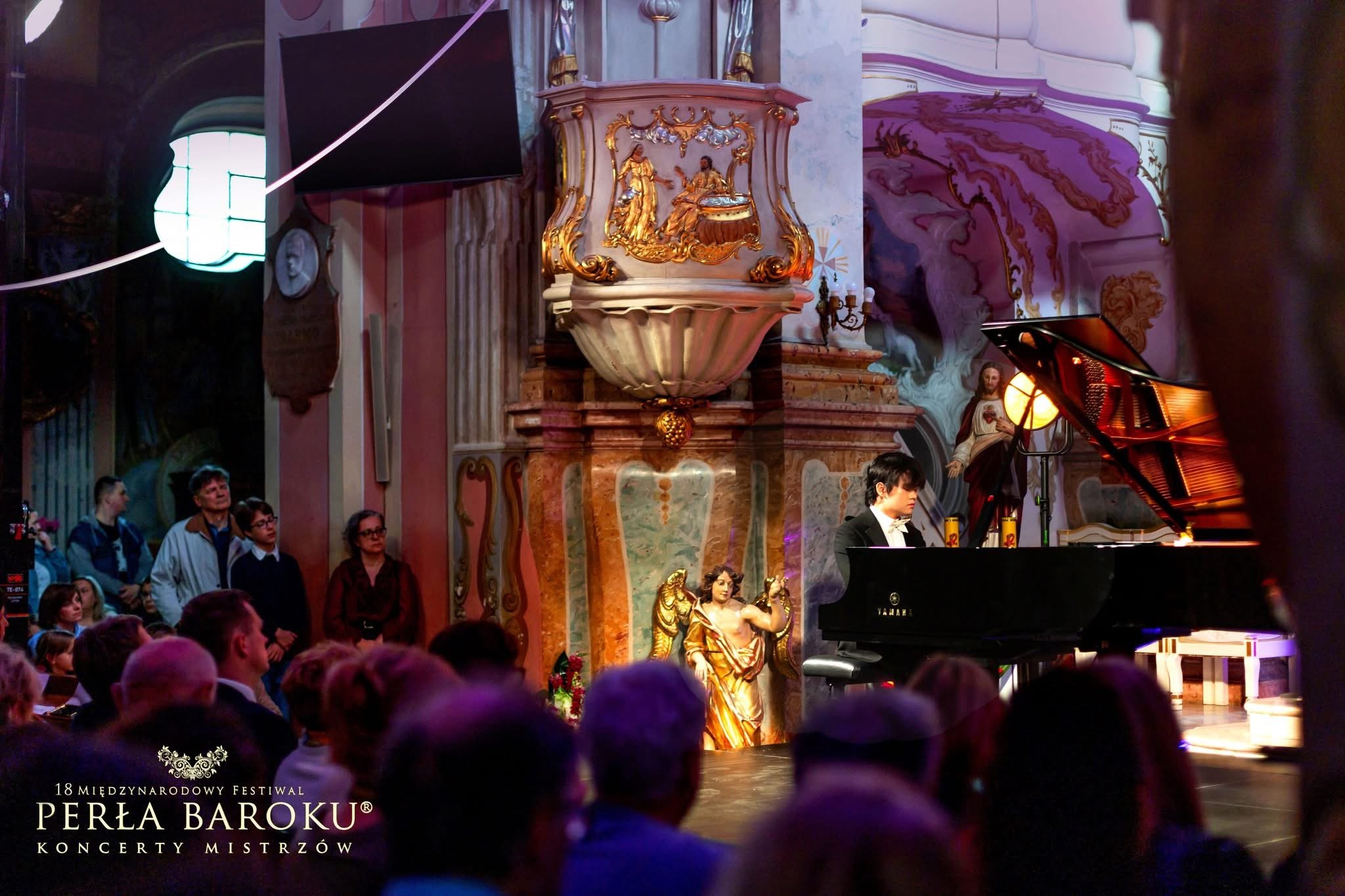 Hao Rao pianist performing on a concert stage in a church, with ornate baroque interior, audience members watching, and decorative statues around.