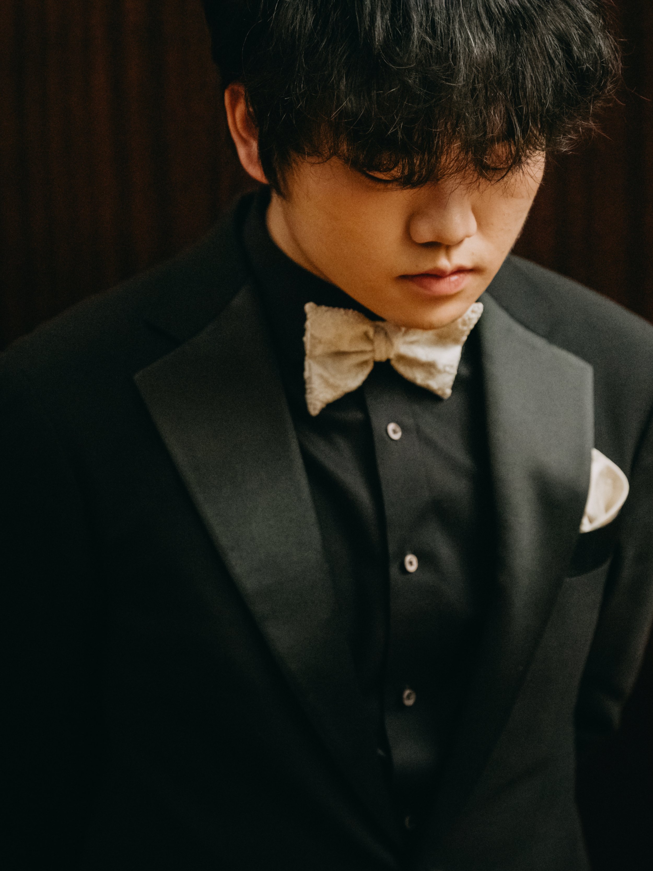 Hao Rao, pianist, formal portrait in a black tuxedo with bow tie.