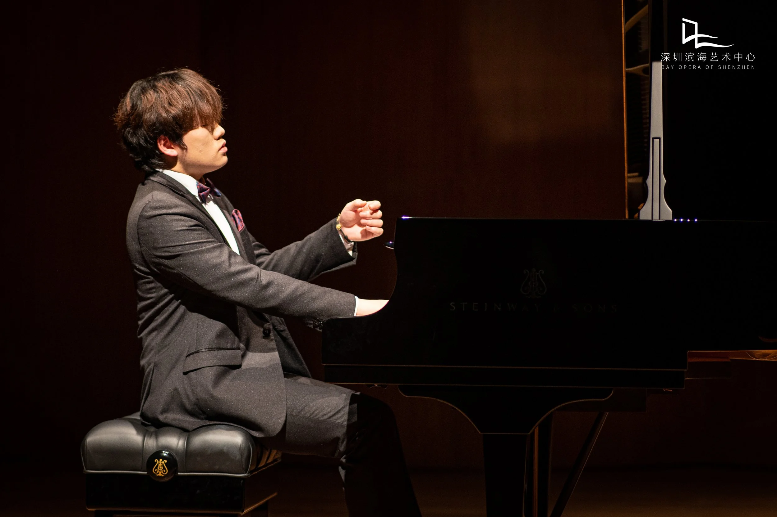 Hao Rao on stage with a dark background at Bay Opera of Shenzhen.