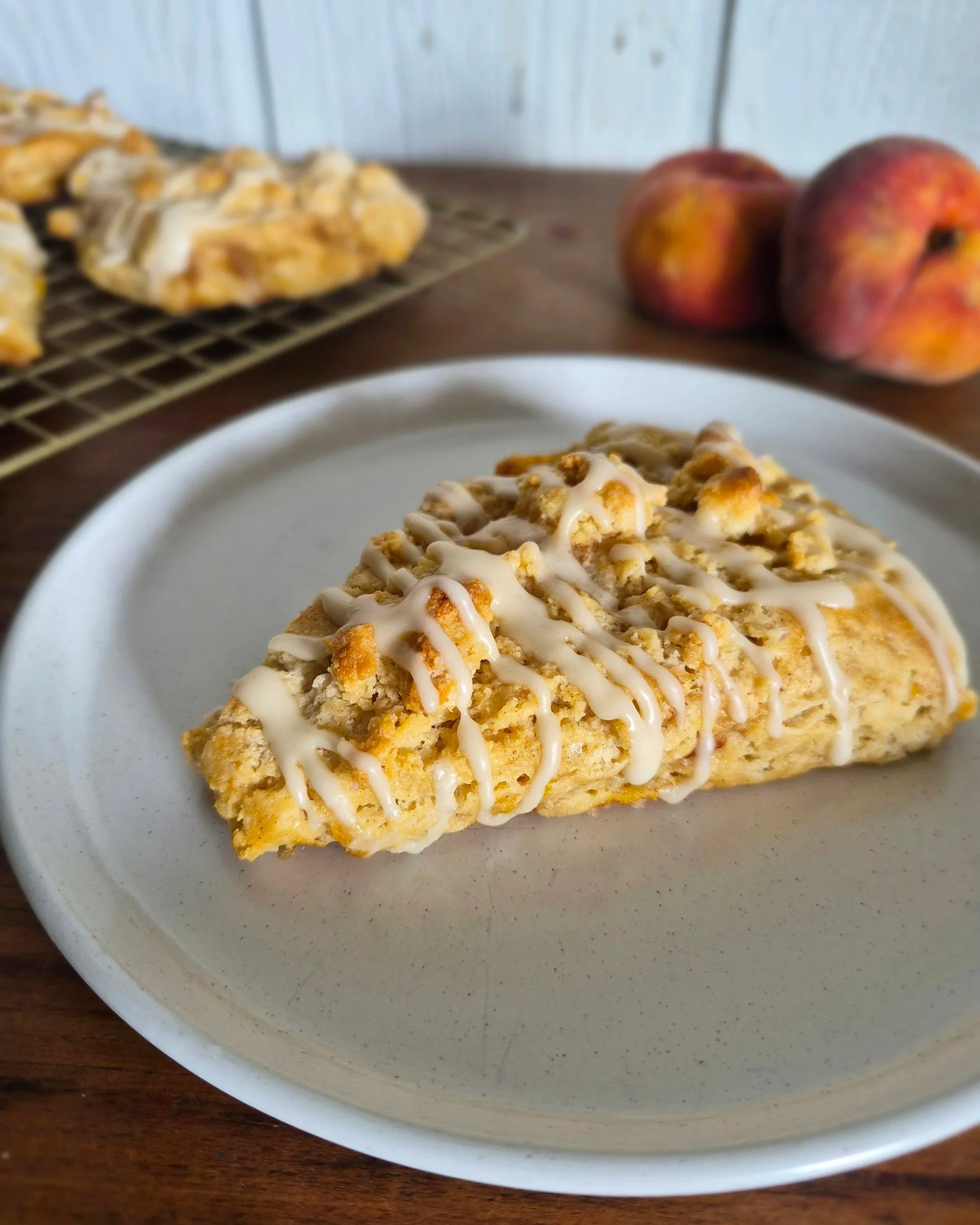 Gluten-free peach cobbler scones with fresh peaches, cinnamon-spiced filling, crumble topping and vanilla drizzle from Marigolds and Grace Kitchen in Victoria BC.
