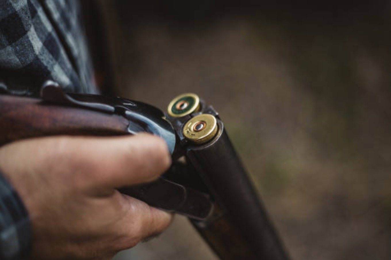 Close-up of a person loading a bullet into the chamber of a hunting rifle.