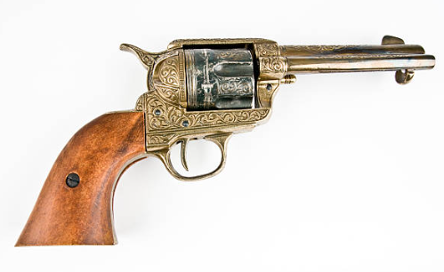 A vintage revolver with an ornate metal design and a wooden handle.