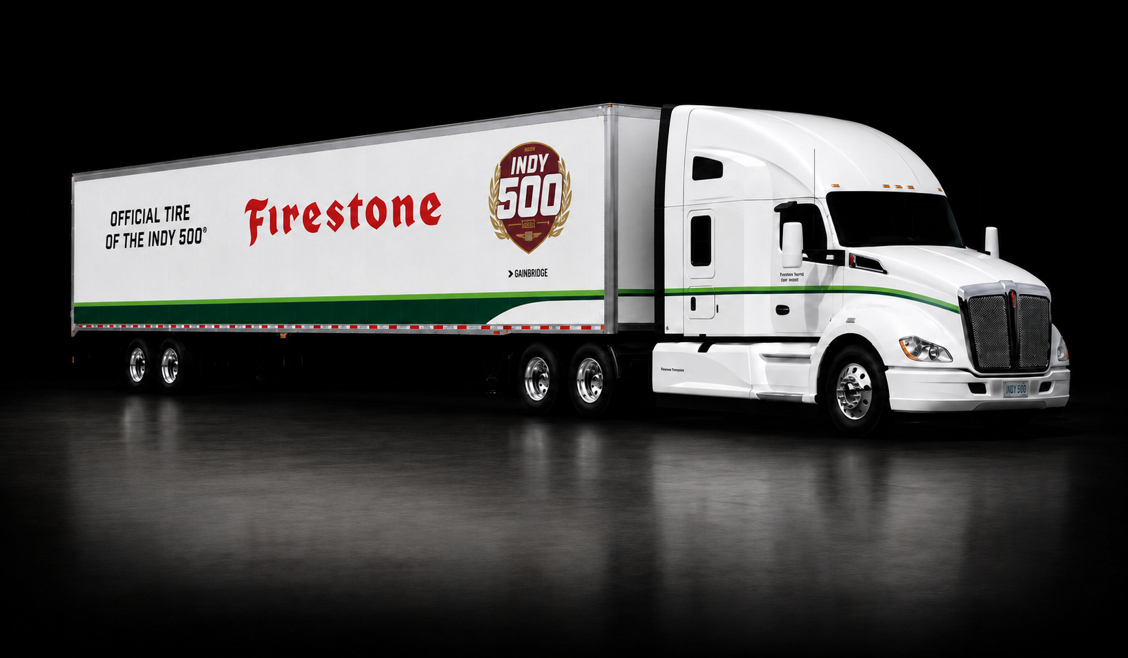 White semi-truck with branding for Firestone and Indy 500 on the side, set against a black background.