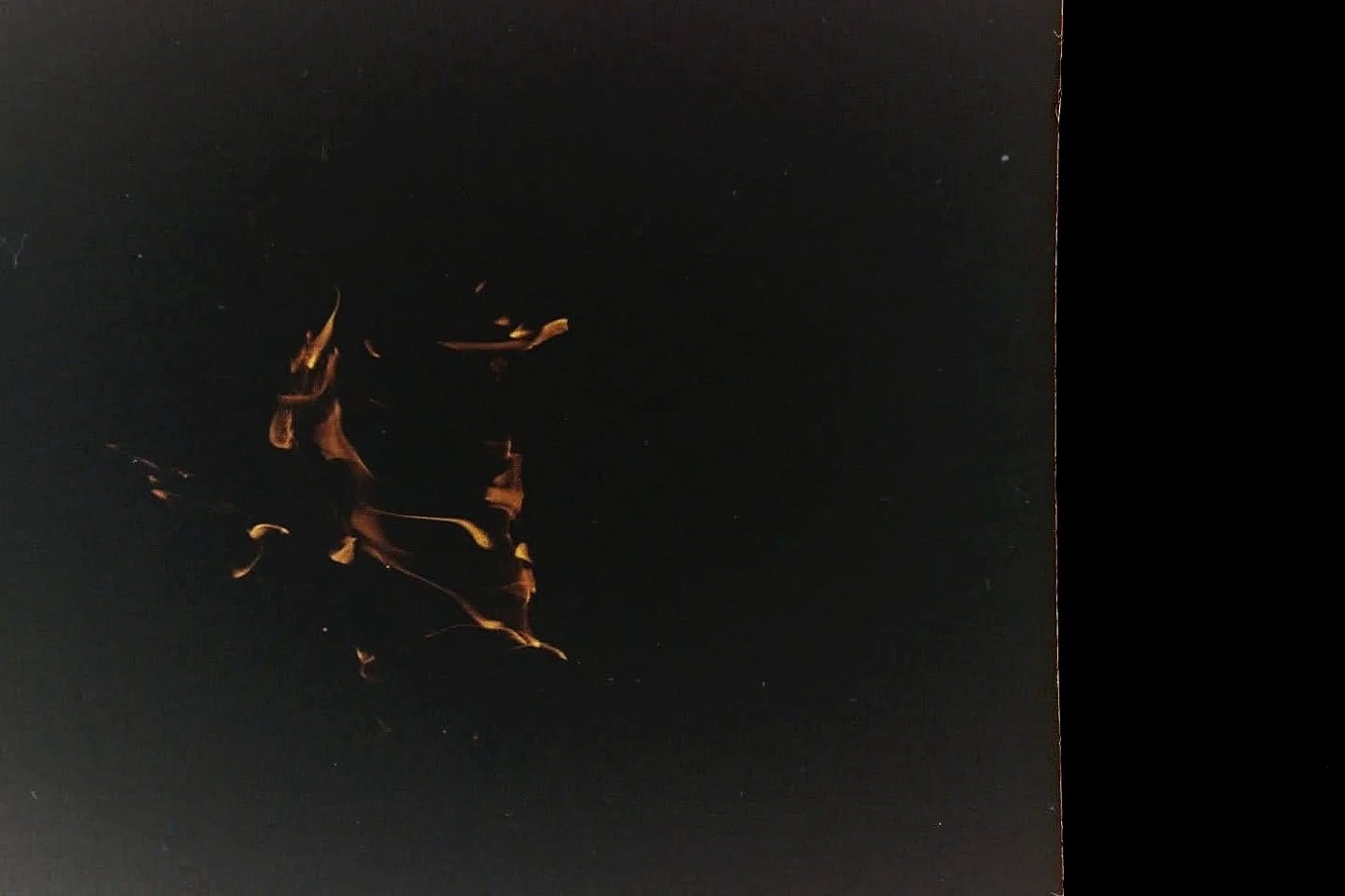 film picture of flames and fire, dark with flickering orange streaks.