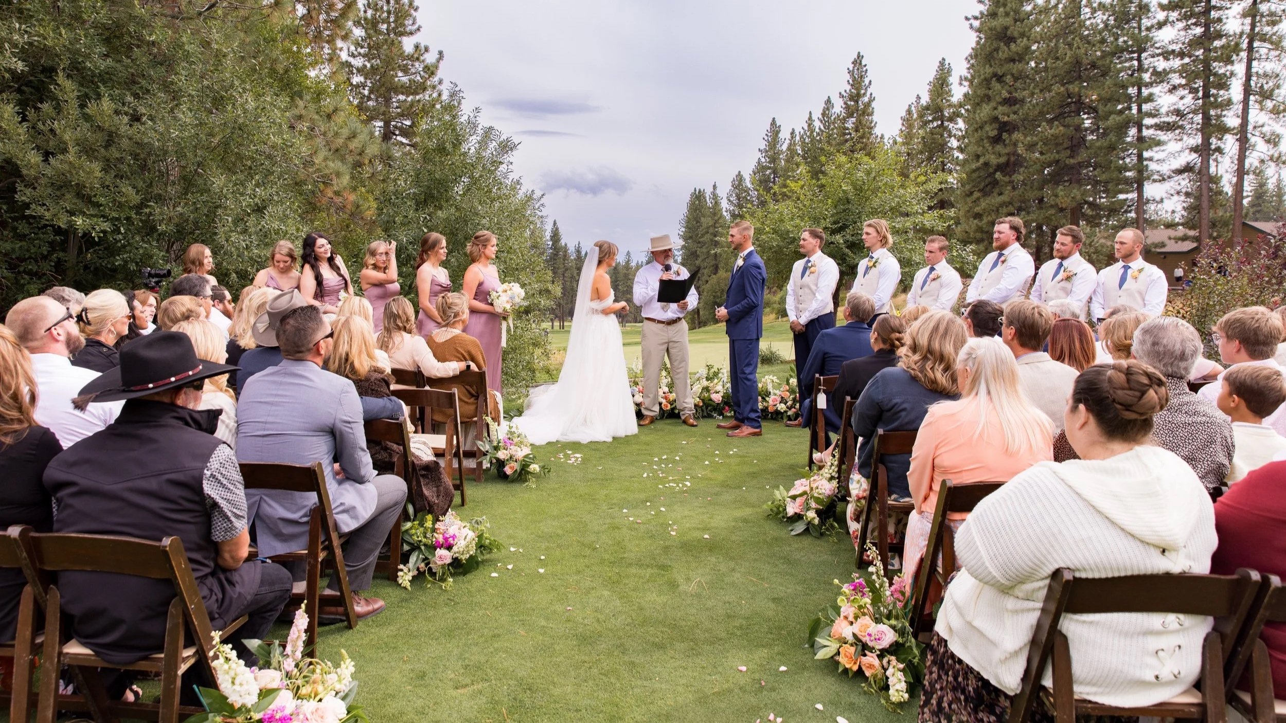 Wedding guests gathered to witness an outdoor ceremony, highlighting the role of community and shared celebration in marriage.