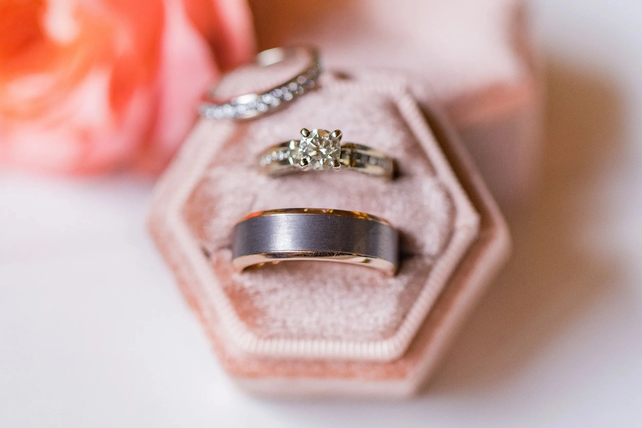 Wedding rings in a blush velvet ring box with soft romantic florals at a Northern Nevada wedding.