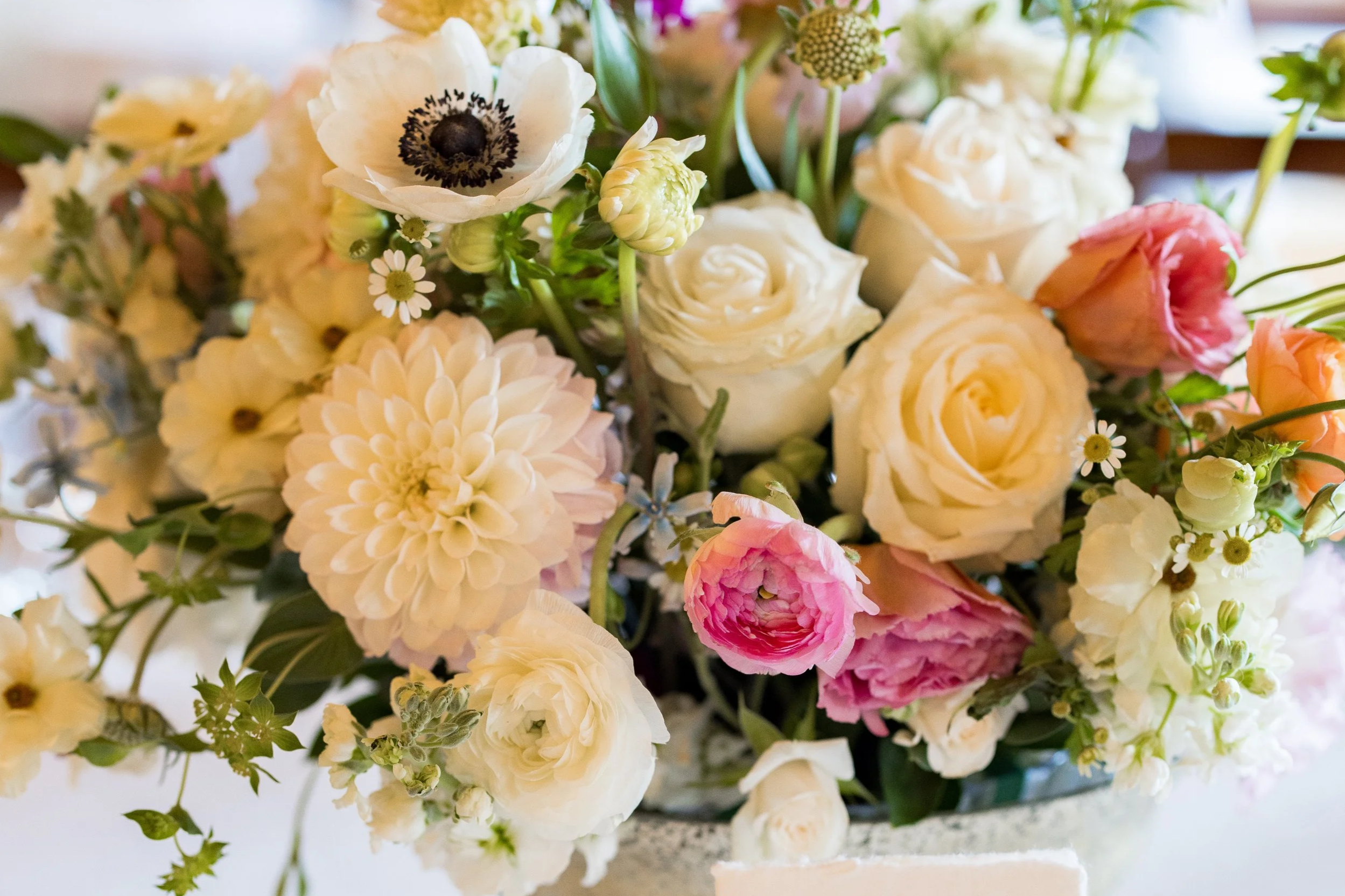 Romantic wedding centerpiece with pastel florals and modern table number styling at an elegant reception.